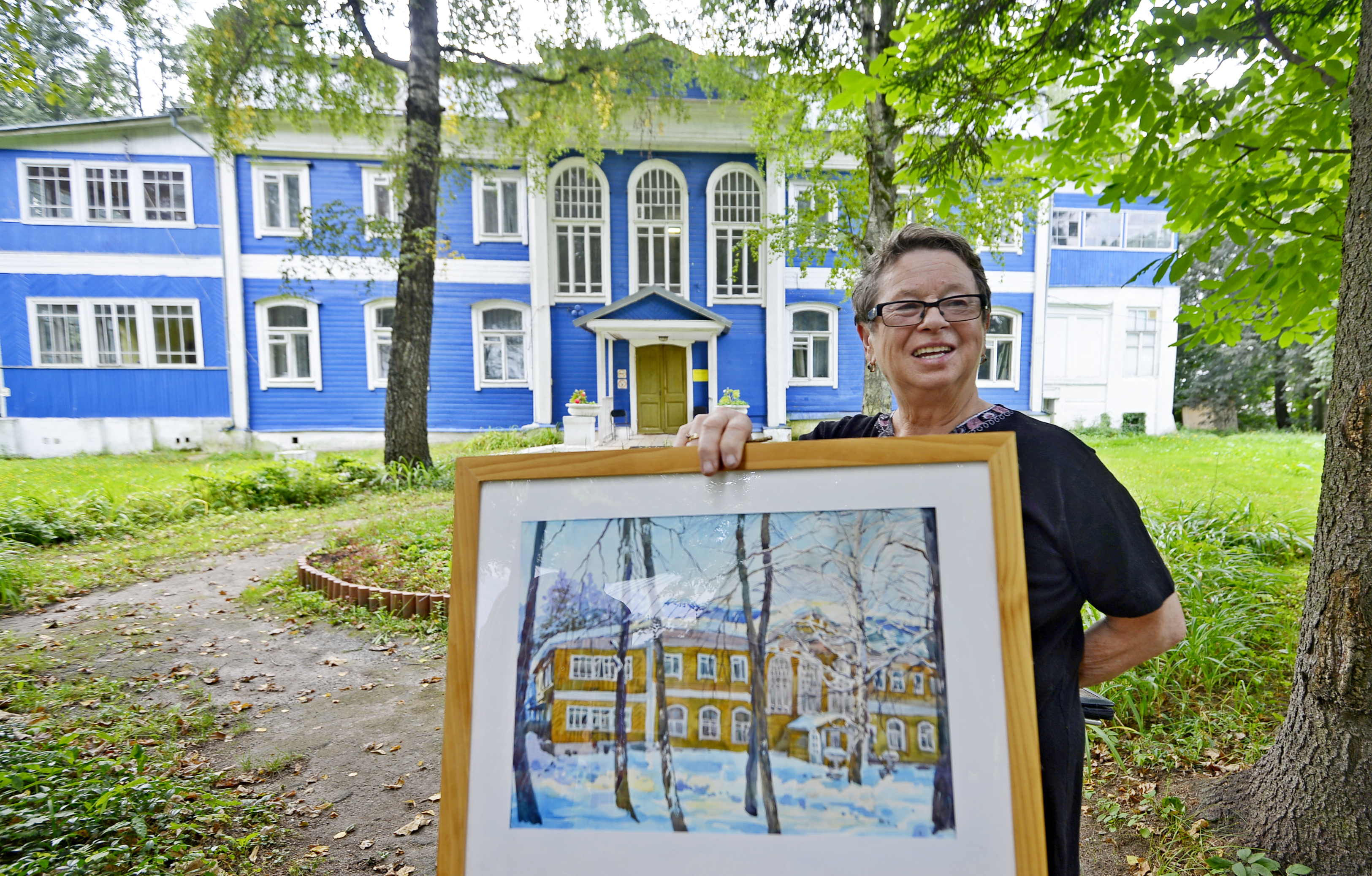 Алла Орлова показывает работу своего студента, изобразившего усадьбу Бараново-Акатово в традиционной для подмосковных имений палитре. В ней обычно использовались светлые тона, но после того как в поместье разместился детский дом, здание выкрасили в синий цвет