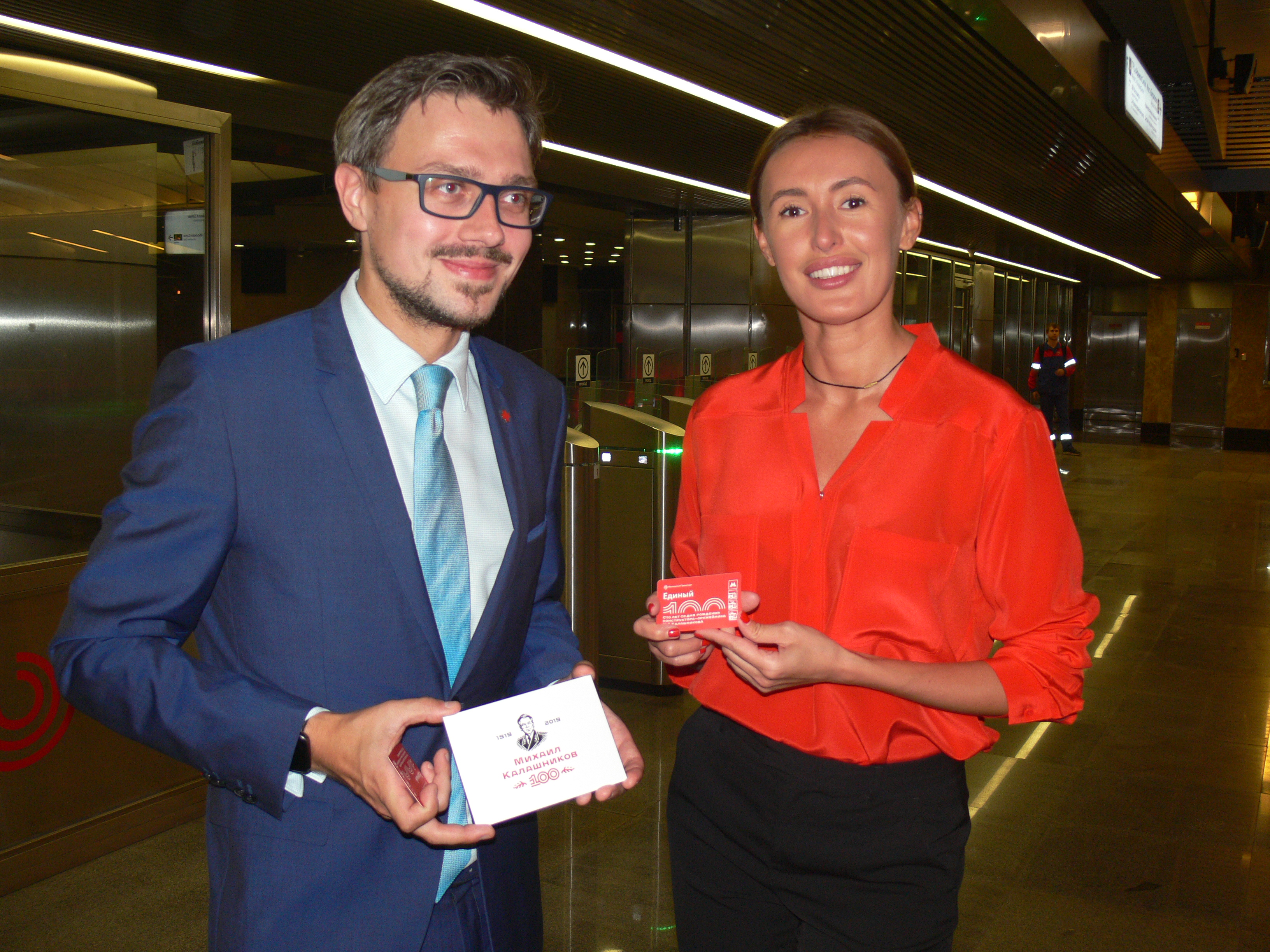 Постпред Республики Удмуртия Михаил Хомич и замначальника Московского метрополитена по развитию клиентских сервисов и работе с пассажирами Юлия Темникова представляют дизайн тематического билета «Единый», посвященного юбилею Калашникова 