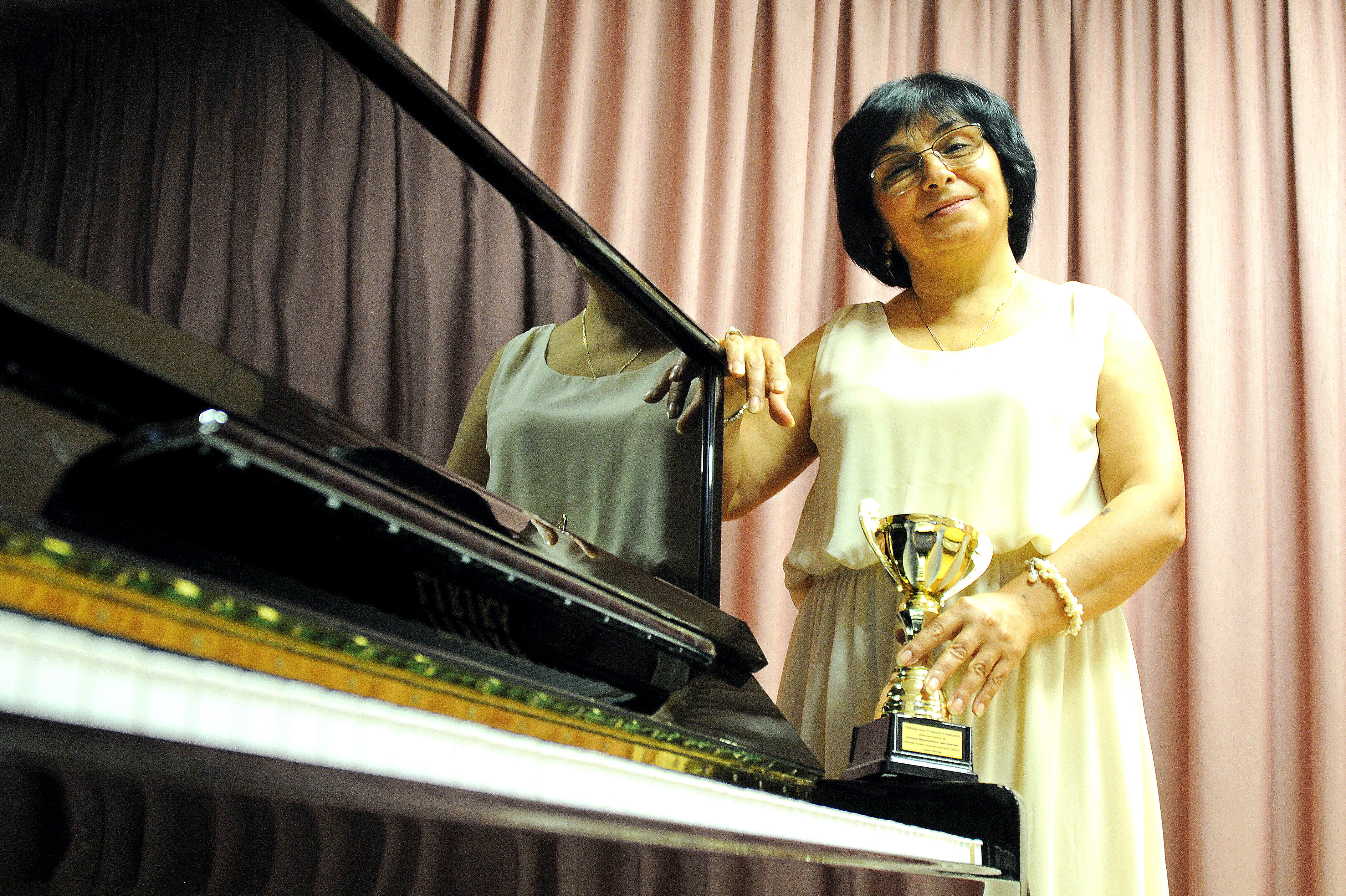 Победительница окружного конкурса «Голос «Московского долголетия» Серафима Дуттова с наградой в руках выступает на концерте «Московских окон негасимый свет» в ТЦСО «Марьино»