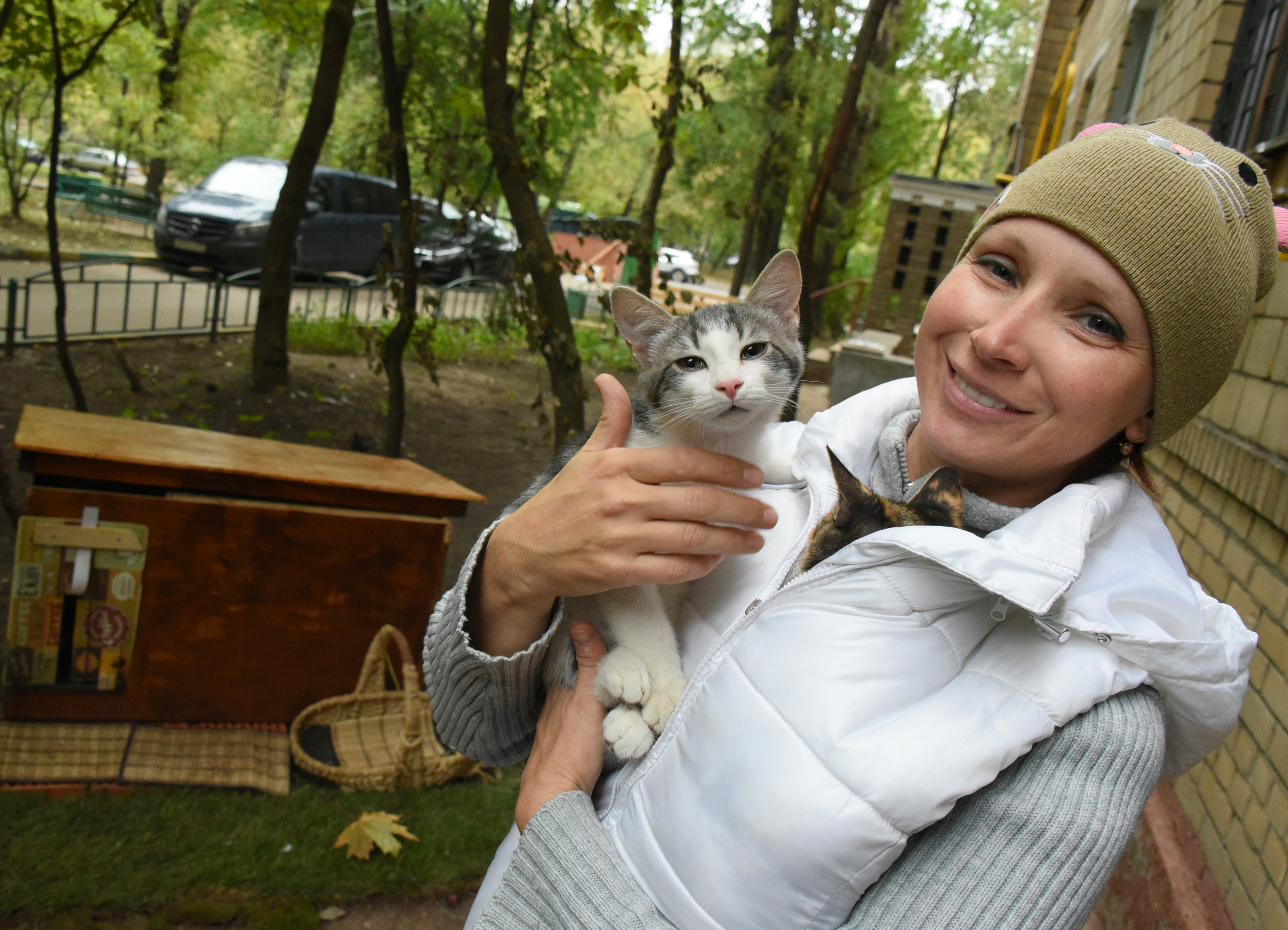 Котята Себастьян и Клевер греются под курткой у местной жительницы 