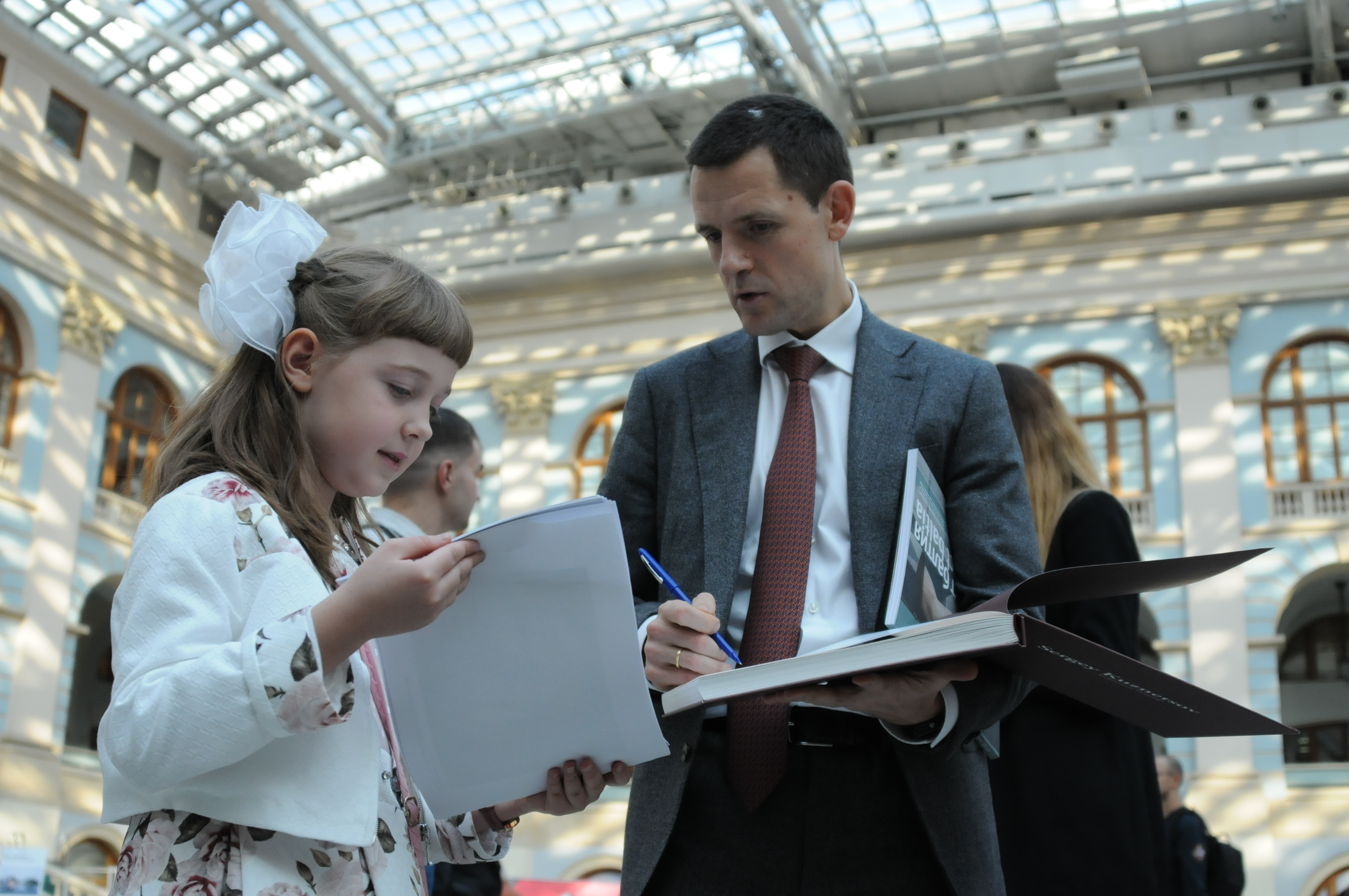 Девятилетняя Юлия Старцева на фестивале «Зодчество» показывает главному архитектору Москвы Сергею Кузнецову свои рисунки. Школьница очень любит рисовать здания и мечтает стать архитектором. Кузнецов, в свою очередь, подарил Юле на память свою книгу с автографом