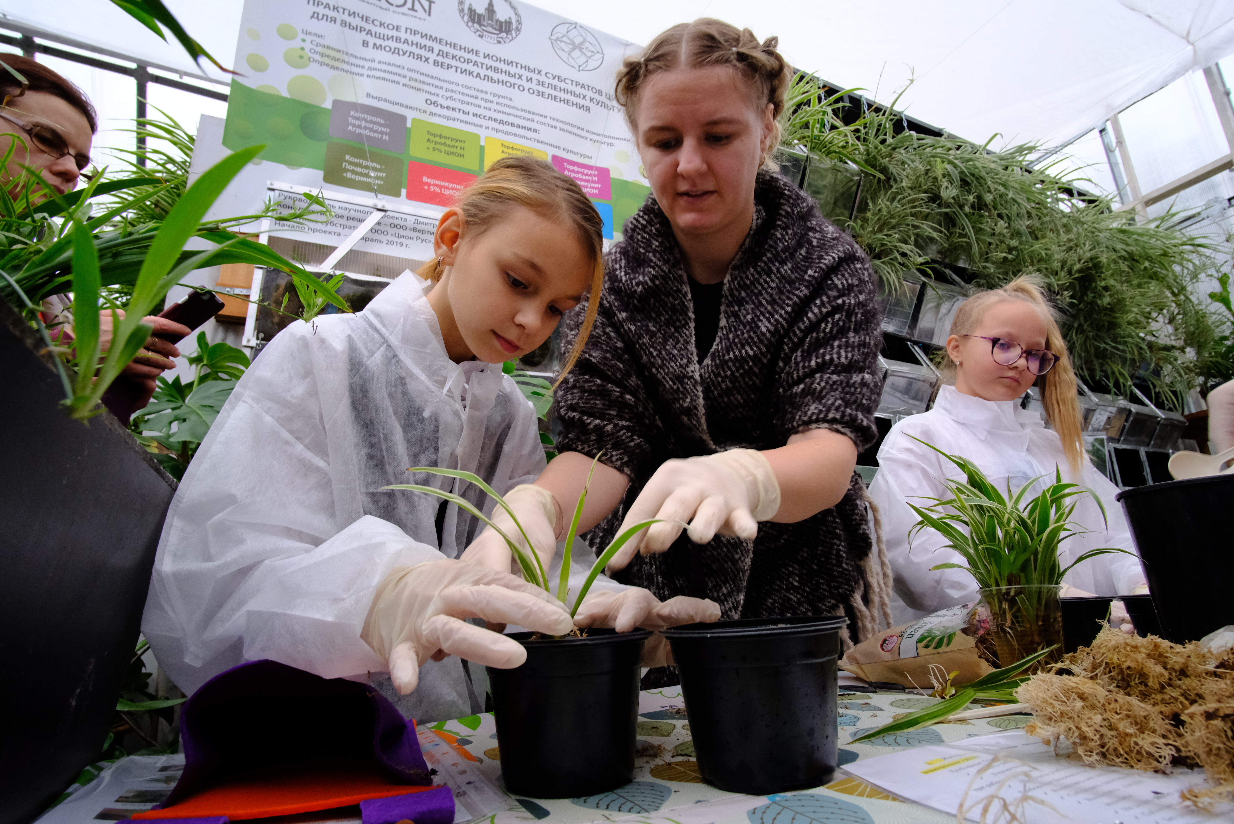 Педагог Екатерина Голикова учит школьницу Альбину Фомину приемам вертикального озеленения