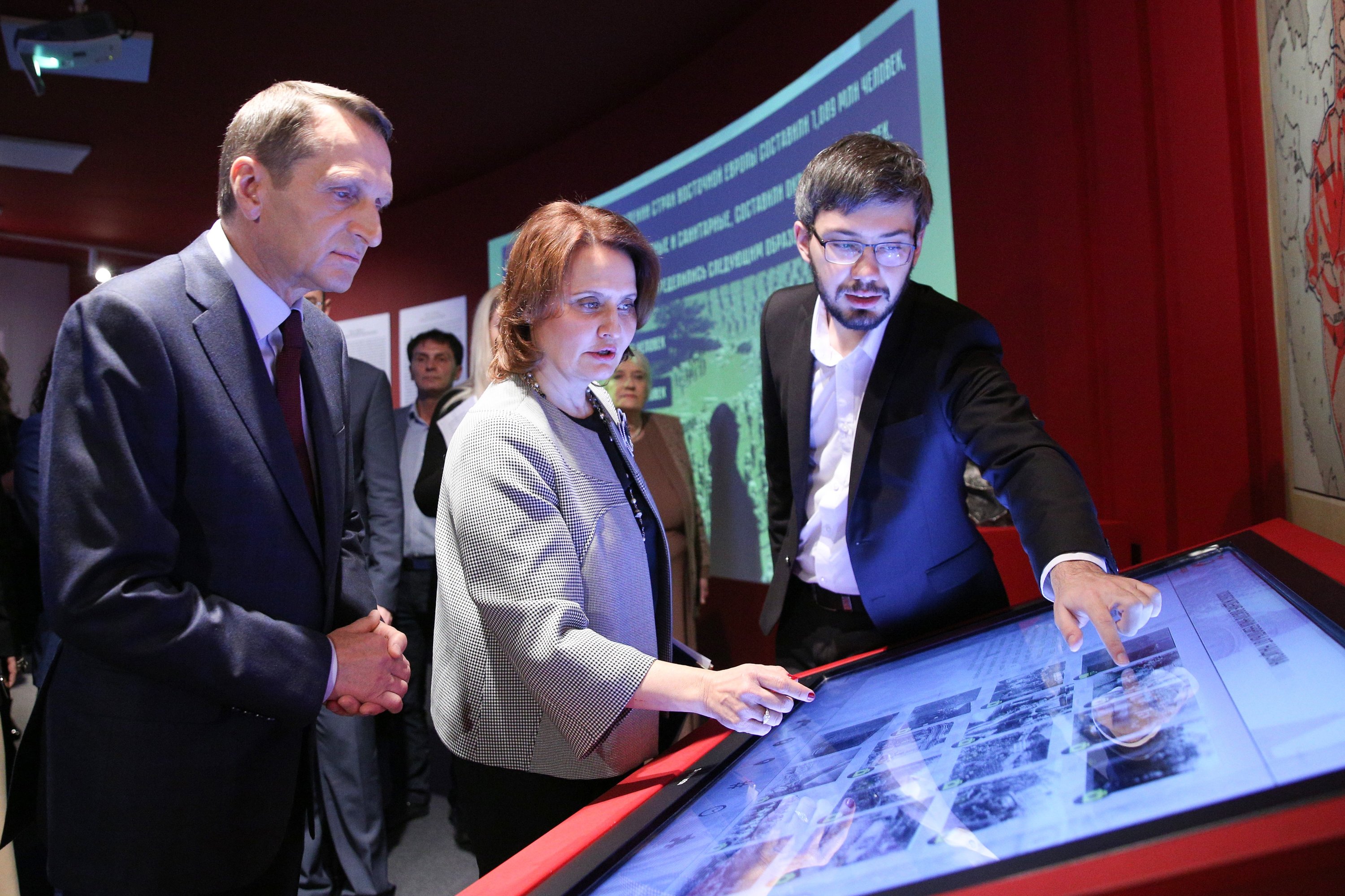 Председатель Российского исторического общества Сергей Нарышкин (слева), гендиректор музея Ирина Великанова, научный сотрудник музея Федор Кукин изучают мультимедийное изображение 