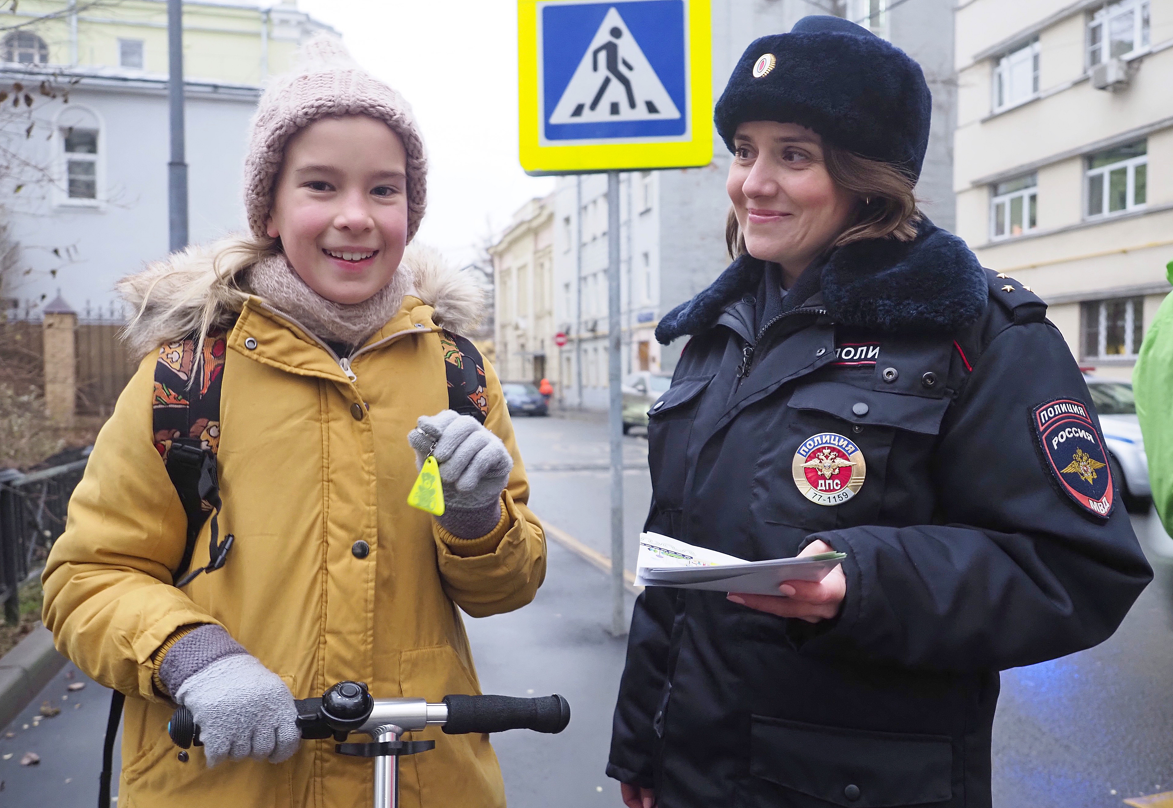 Инспектор Государственной инспекции безопасности дорожного движения Ольга Кузьмина вручила третьекласснице Кате Смирновой светоотражающий брелок и памятку, рассказывающую о Правилах дорожного движения