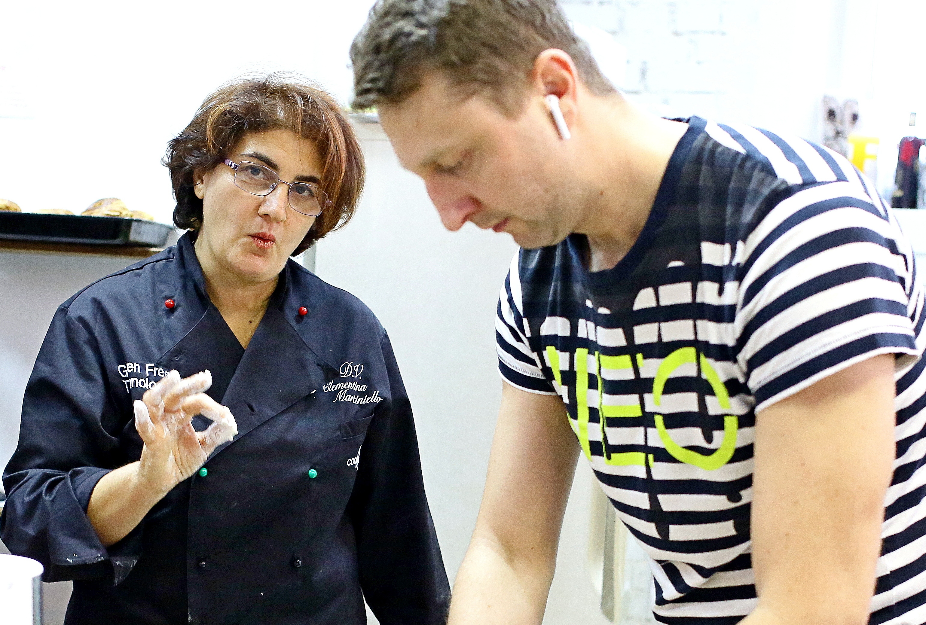 Итальянка Клементина Сильвителла подробно объясняет участнику мастер- класса Виталию Иванову, как правильно делать тесто и его раскатывать, чтобы получилась идеальная итальянская пицца