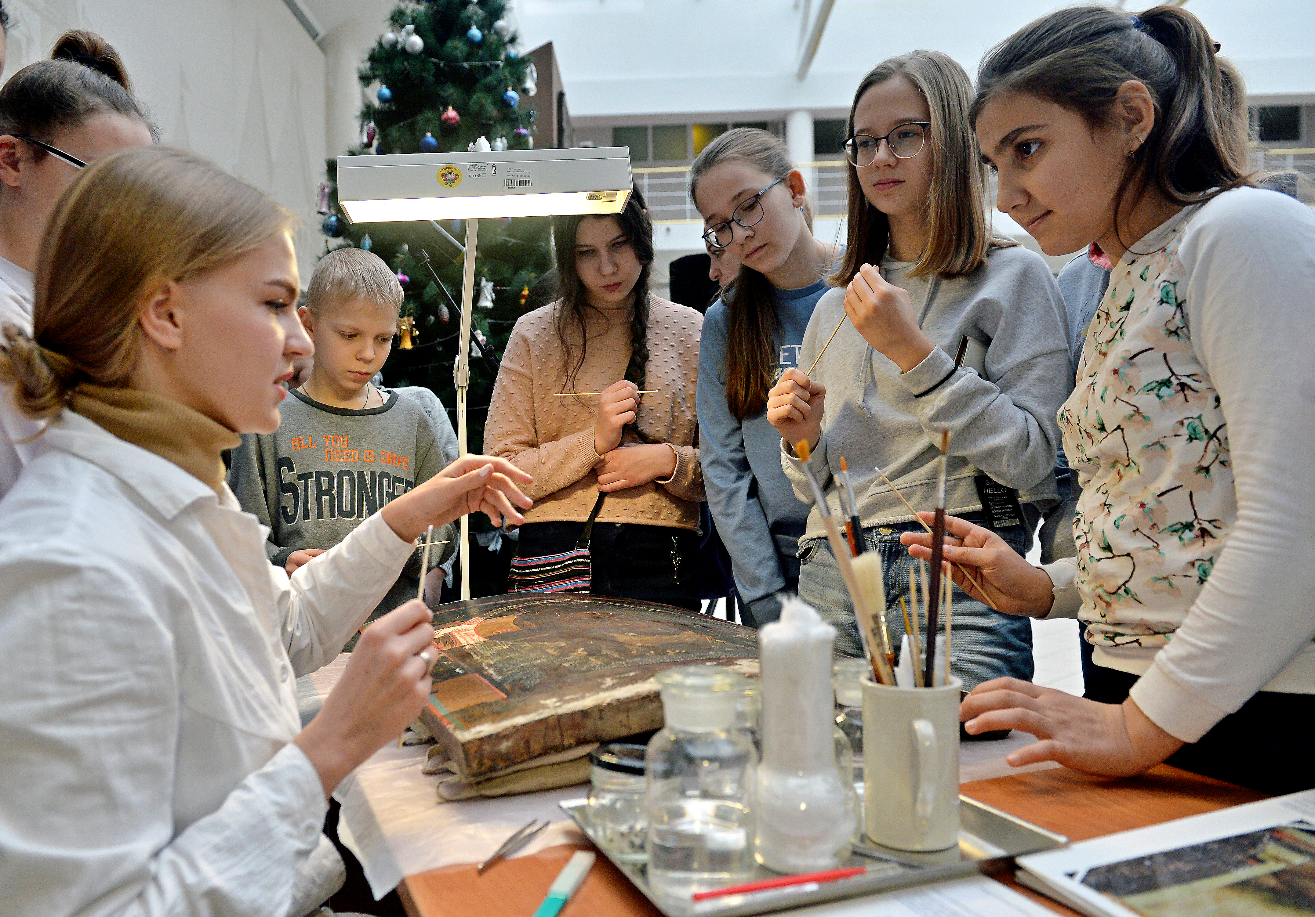 Екатерина Машкова (слева на переднем плане) проводит для школьников мастер-класс по реставрации старинных икон