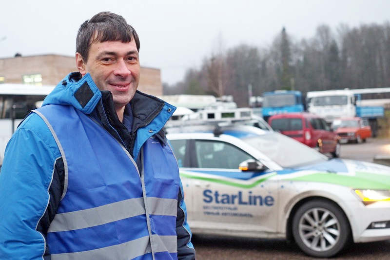 Руководитель команды из Санкт-Петербурга Борис Иванов демонстрирует разработку — беспилотный автомобиль (на заднем плане)