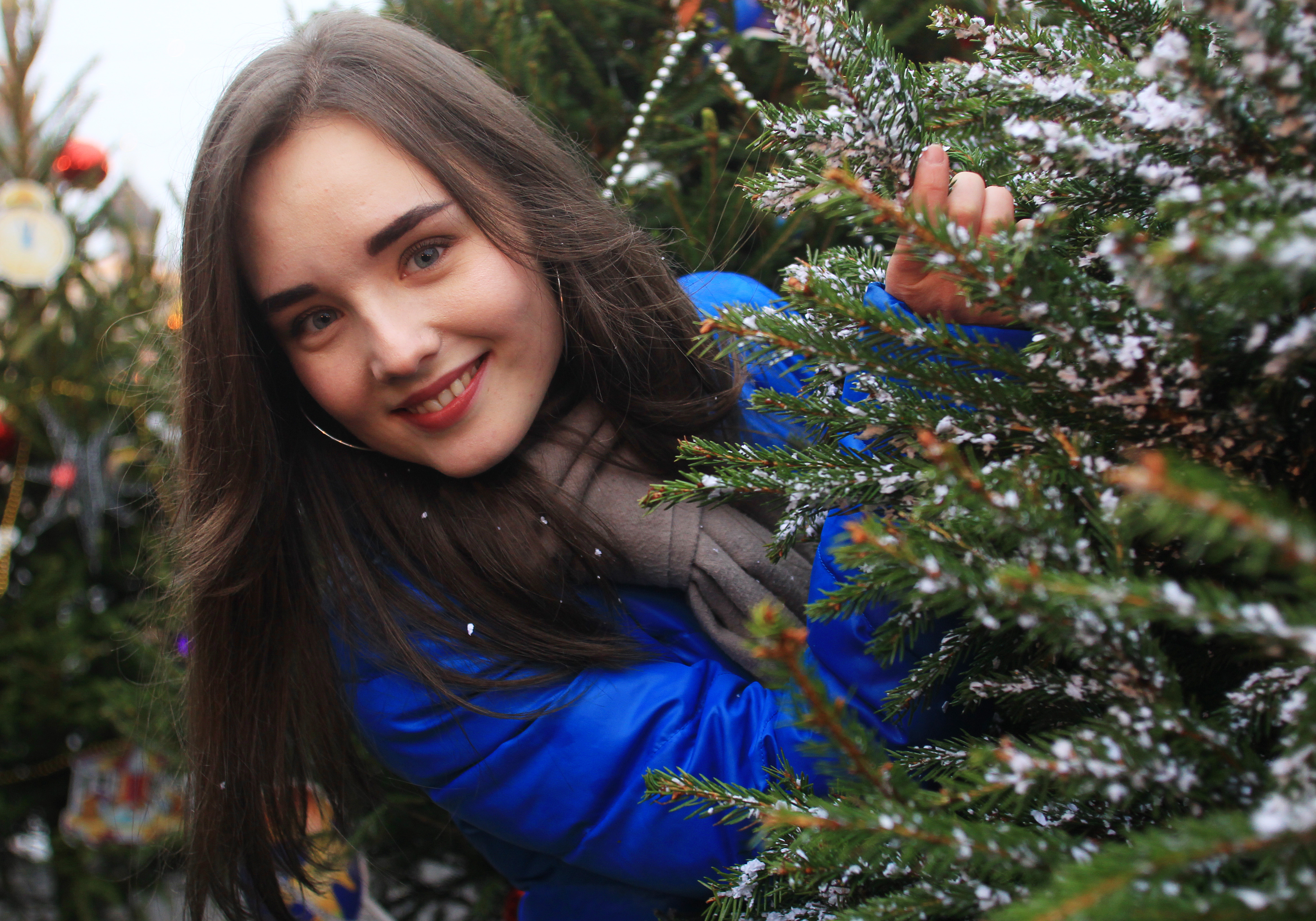 Москвичка Карина Штейман любуется живыми елями, установленными к Новому году в центре Москвы