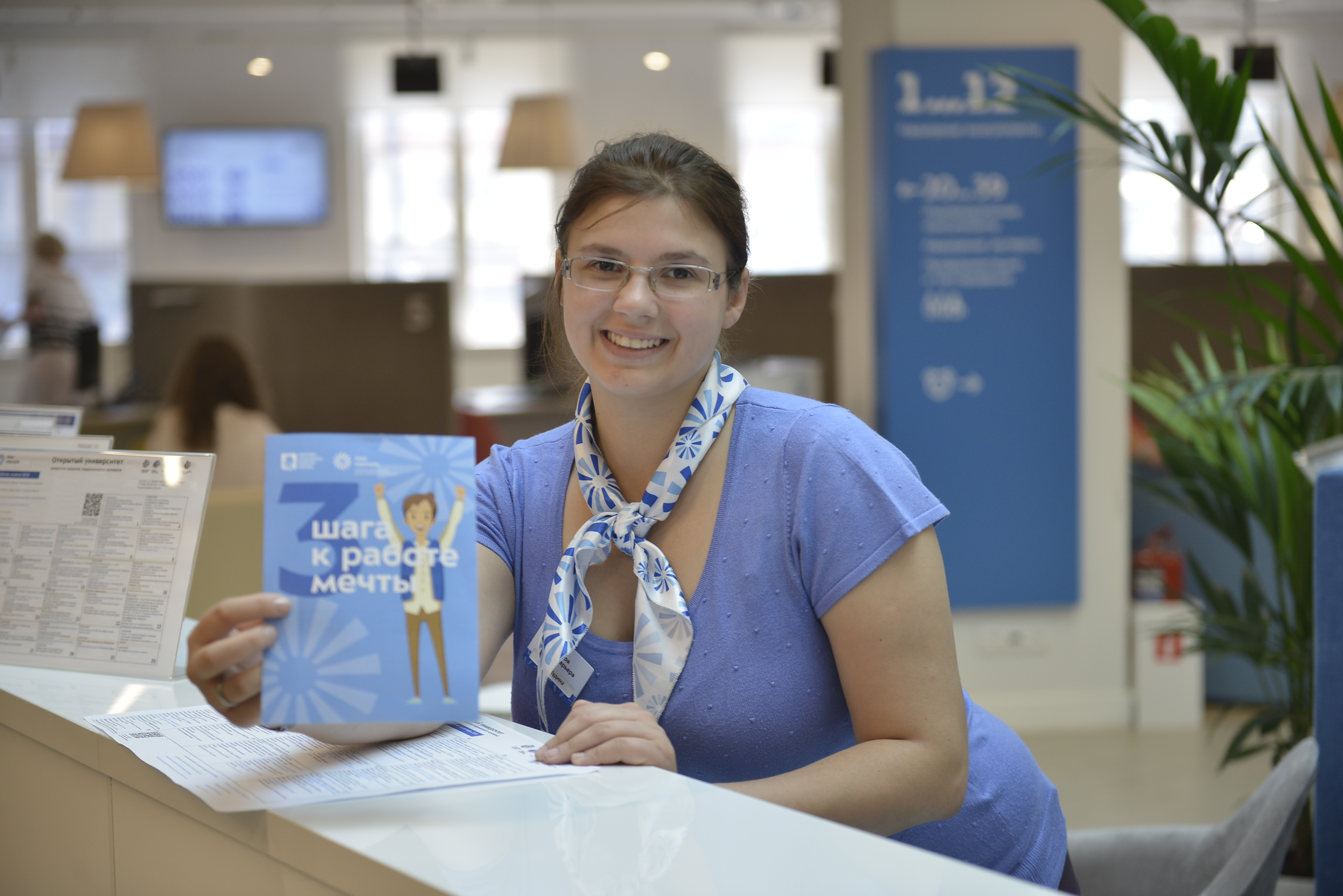 Сотрудница центра занятости населения Москвы «Моя карьера» Юлия Кудина демонстрирует брошюру для соискателей
