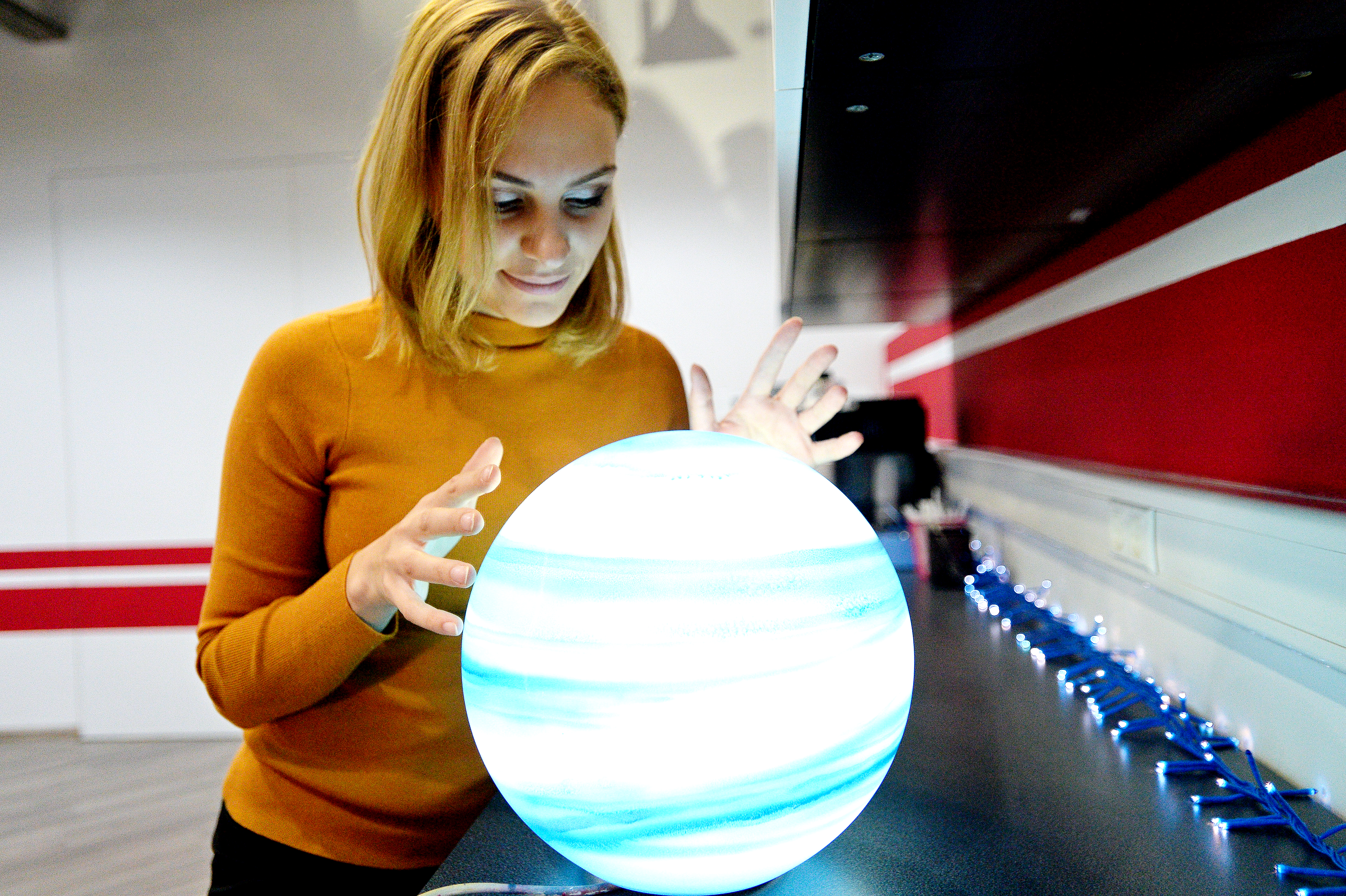 Сотрудник компании по 3D-печати Маргарита Булгакова с арт-объектом — планетой Нептун