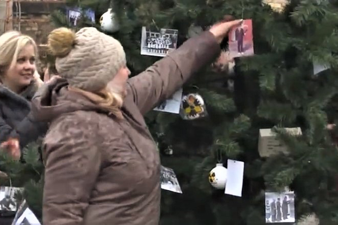 Праздничное дерево украсили новогодними игрушками и фотографиями из детства