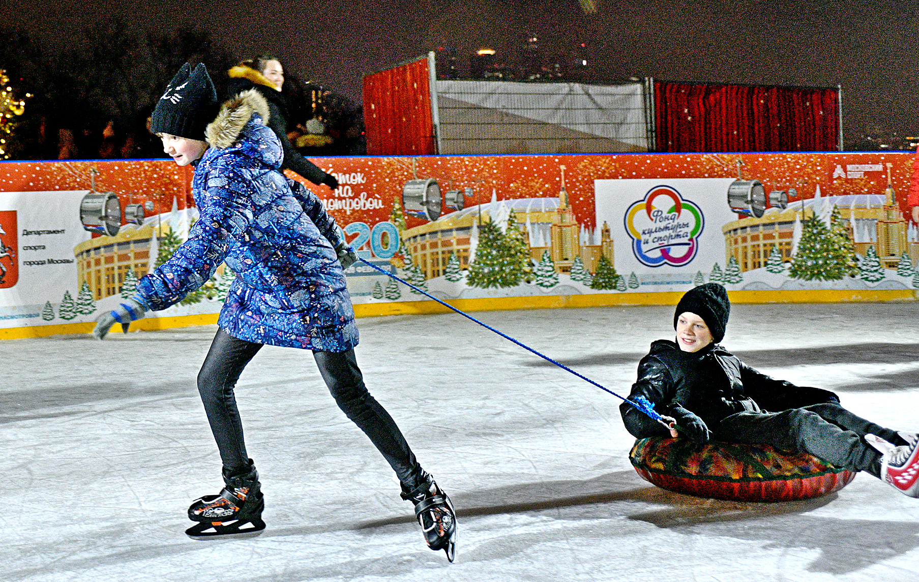 Юные москвичи Арина Сафонова и Михаил Боков во время состязания по буксировке ватрушек на скорость