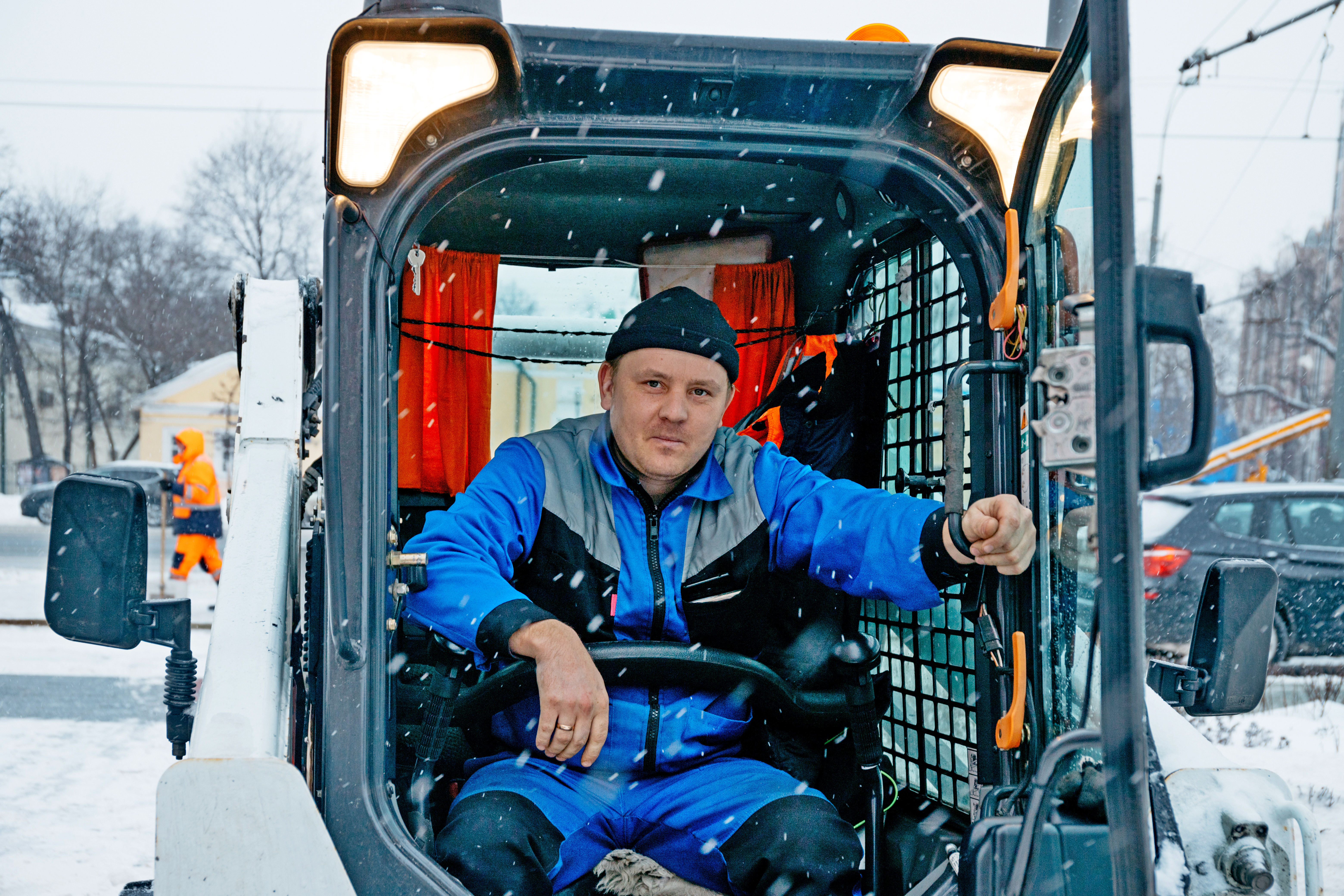 На вооружении столичных коммунальных служб много различной специализированной техники, в том числе мини-погрузчики, которые удобно использовать для очистки тротуаров, площадей и пешеходных дорожек. Один из водителей такой машины — Антон Кузнецов