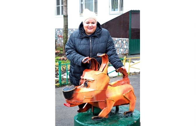 Председатель ЖСК «Отрадное» Кристина Горанская показывает металлическую фигурку пса