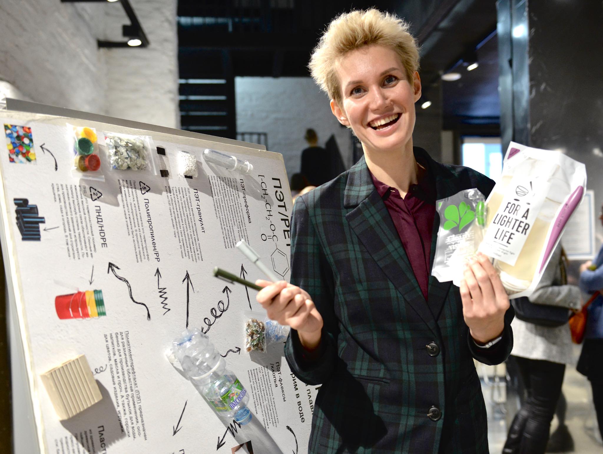 Менеджер шведской компании по производству перерабатываемых упаковок для молока и пищевых жидкостей Татьяна Лунг демонстрирует первичный вид продукции и произведенные из утилизированного пластикового пакета шариковые ручки