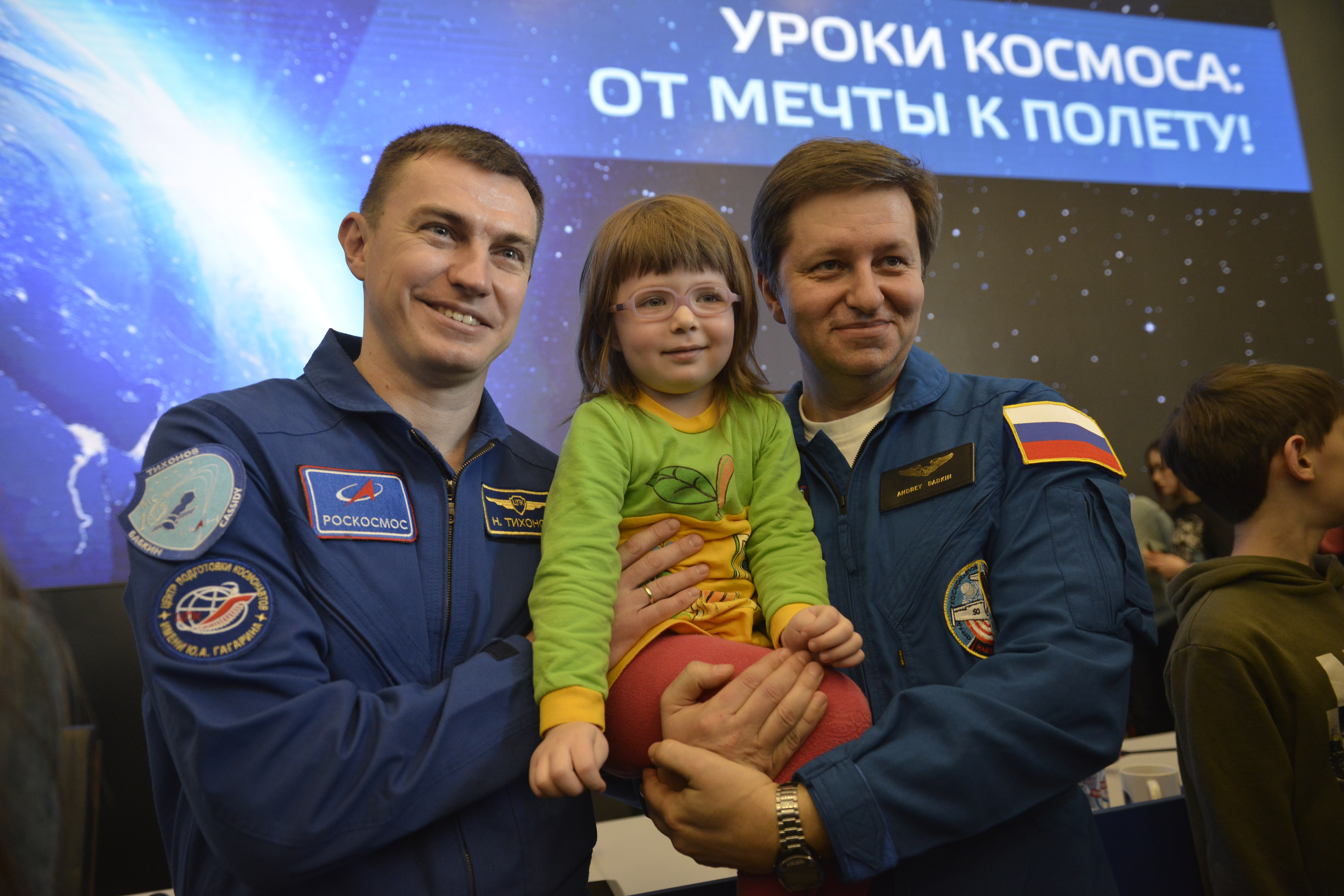 Космонавты Николай Тихонов (слева) и Андрей Бабкин вместе с четырехлетней москвичкой — поклонницей космоса Ярославой Борисовой на встрече с посетителями центра «Космонавтика и авиация» на ВДНХ