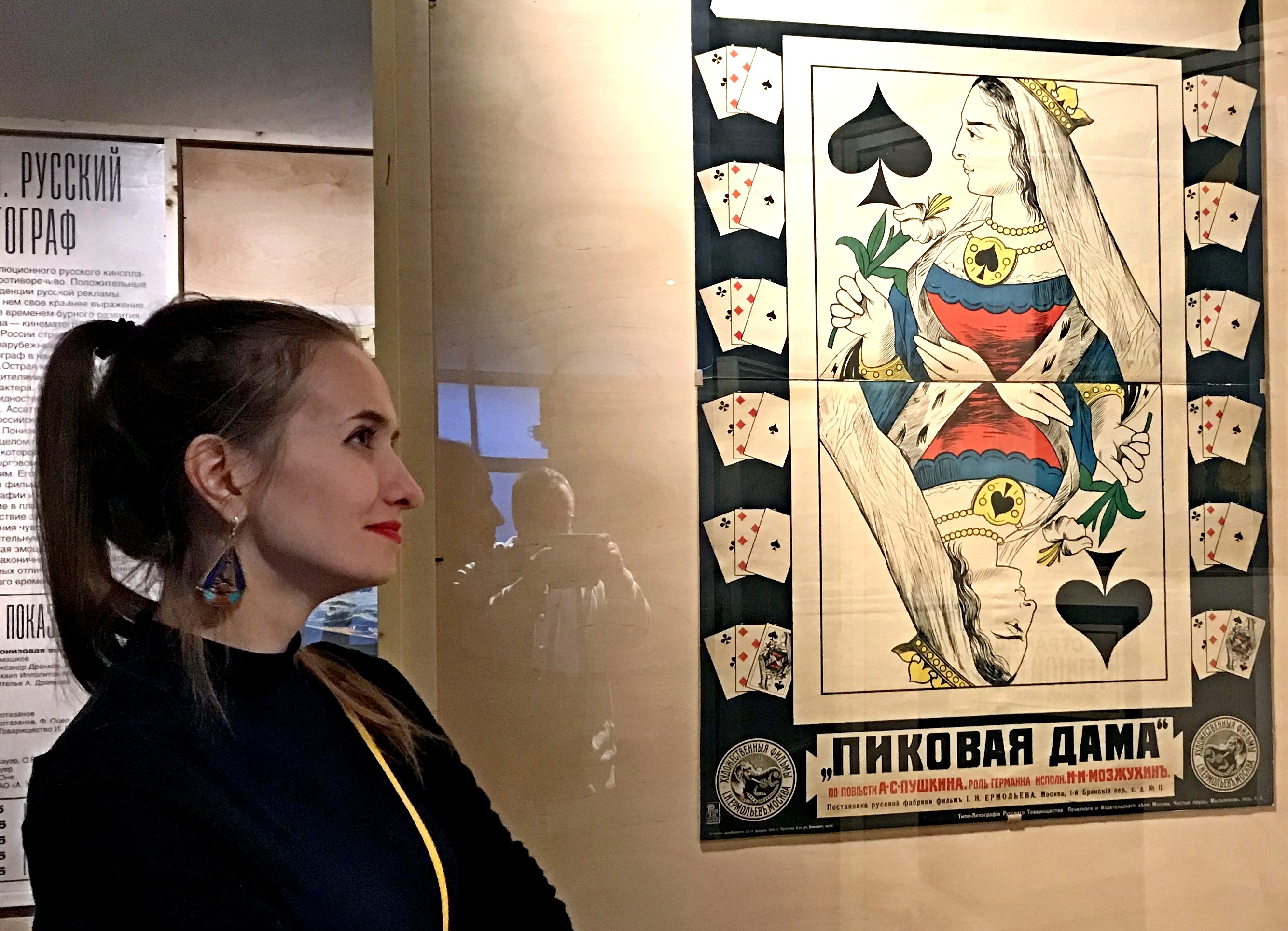 Экскурсовод Дарья Хадеева перед афишей немого фильма «Пиковая дама»