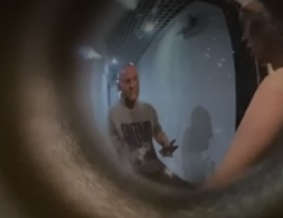 На кадрах видно, как негодующий сосед снует по коридору взад и вперед, время от времени подходя к двери квартиры блогера