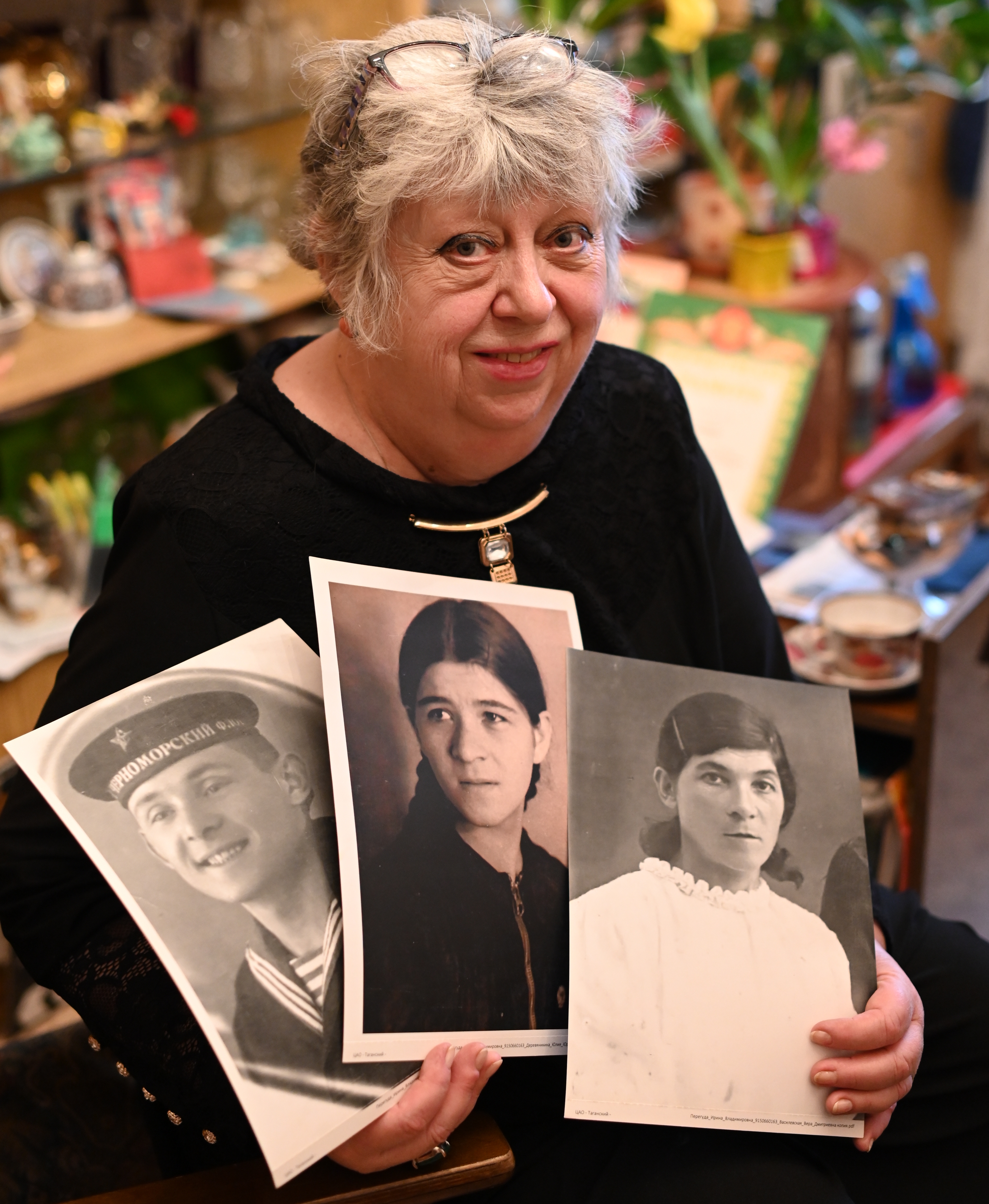 Ирина Перегуда показывает фотографии своих дяди, мамы и бабушки (справа), ветеранов Великой Отечественной войны 