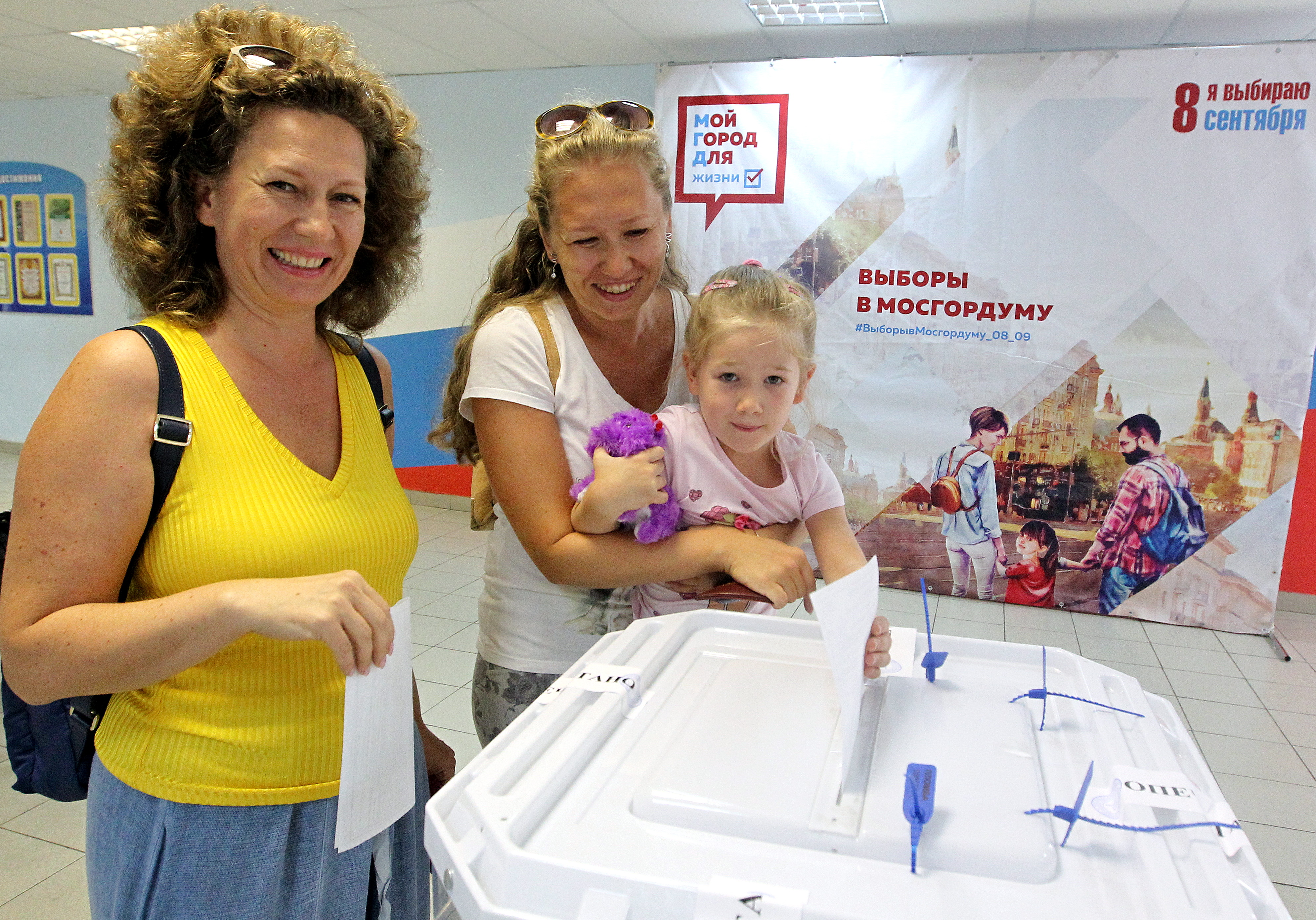 Москвички Светлана Комиссарова (слева), Александра Иноземцева и маленькая Даша Платова голосуют на выборах в Мосгордуму