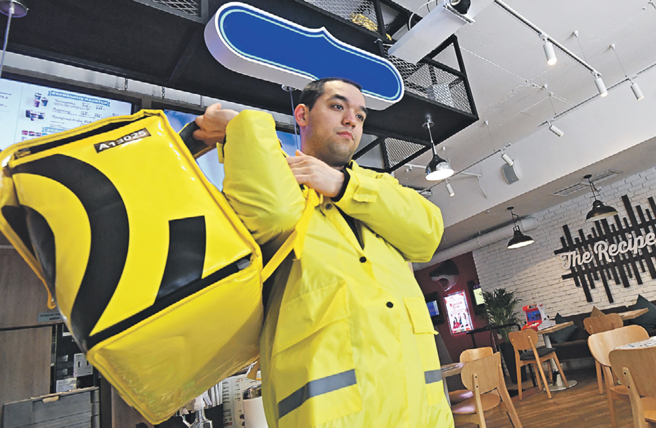 Курьер популярного сервиса доставки еды забирает заказ клиента в одном из заведений-партнеров в Москве. Малый и средний бизнес сейчас выживает как может 