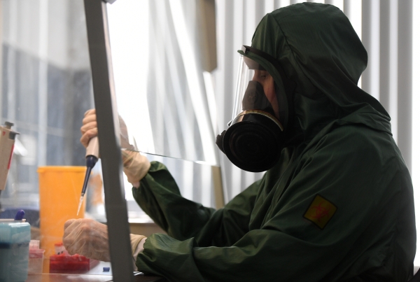 Сотрудник в костюме биозащиты за работой в вирусологической лаборатории Центра гигиены и эпидемиологии Роспотребнадзора, где производится анализ на новую опасную коронавирусную инфекцию 