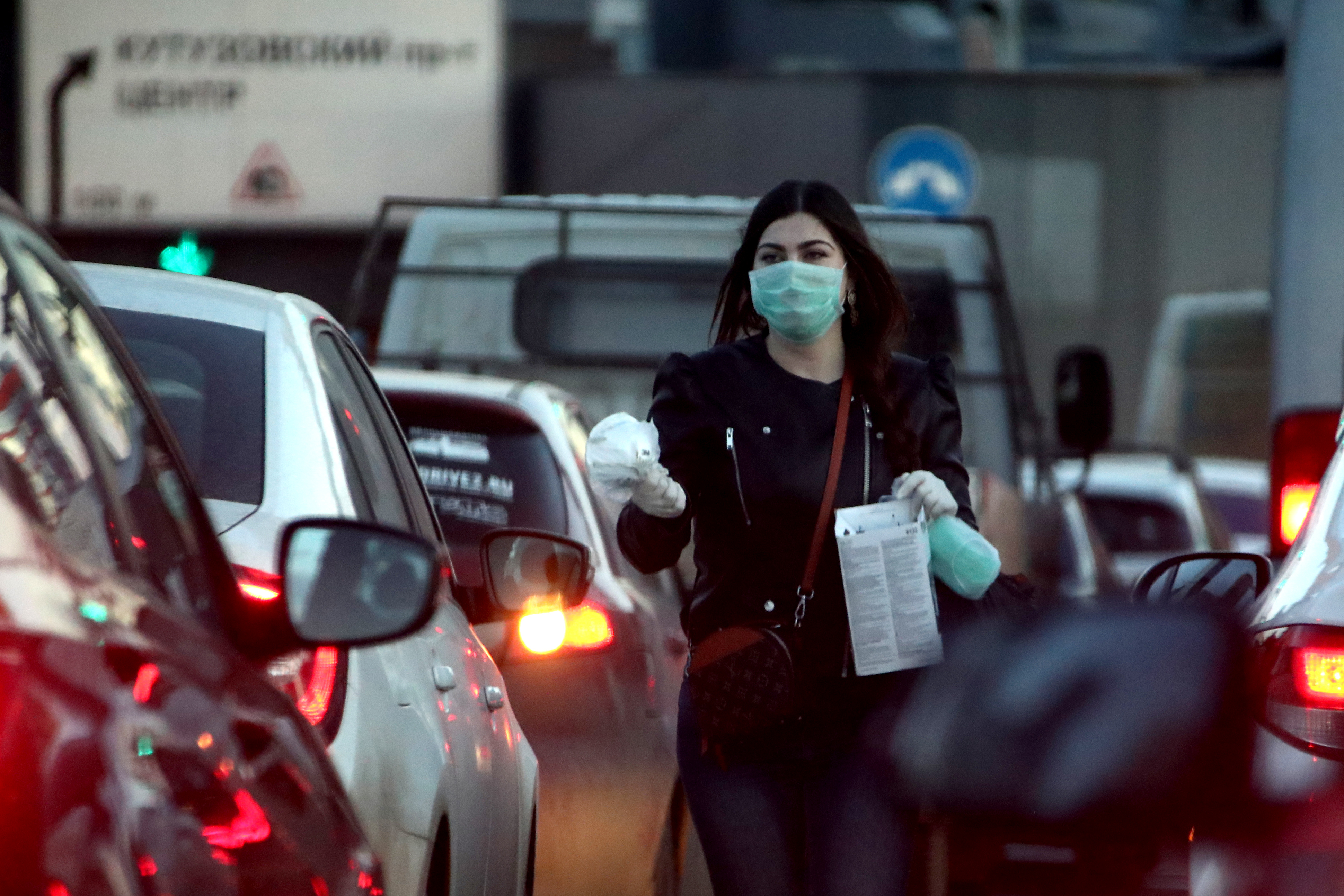 не брать Женщина предлагает купить медицинские маски водителям, которые стоят в пробке на Третьем транспортном кольце