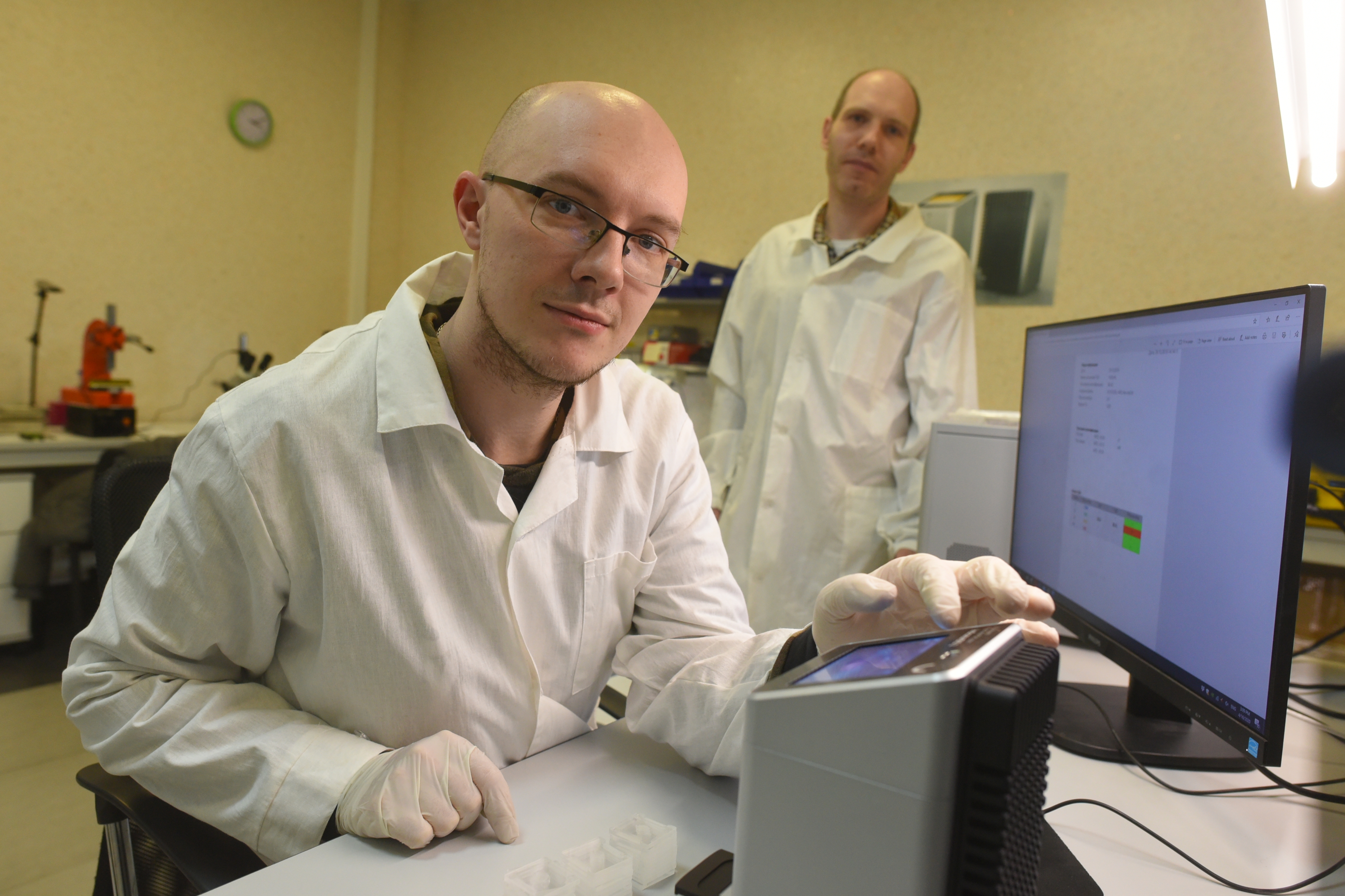 Инженер-исследователь Стас Пауль демонстрирует анализатор для быстрого выявления вирусов. На заднем плане — гендиректор компании-разработчика Евгений Горский 