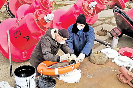 Капитан теплохода «Путейский» Константин Карпачев (слева) и моторист-рулевой Евгений Кондрашов обновляют надписи на спасательном круге