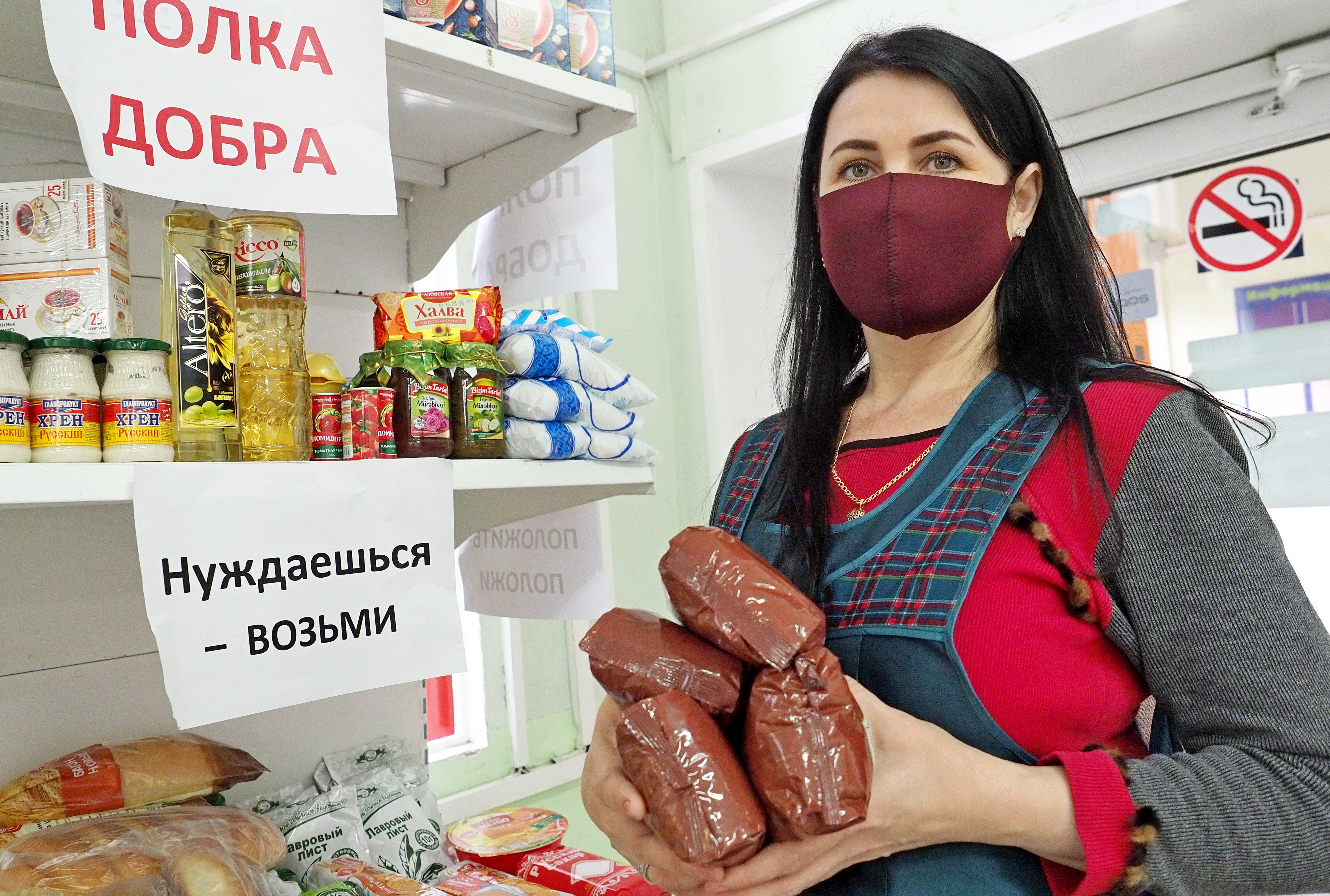 Продавец продуктового магазина на улице Алабяна Наталья Гладких показала ассортимент продуктов на «Полке добра». Жители охотно участвуют в благотворительной акции, оставляя на стеллаже крупы, муку, растительное масло, сладости и консервы  