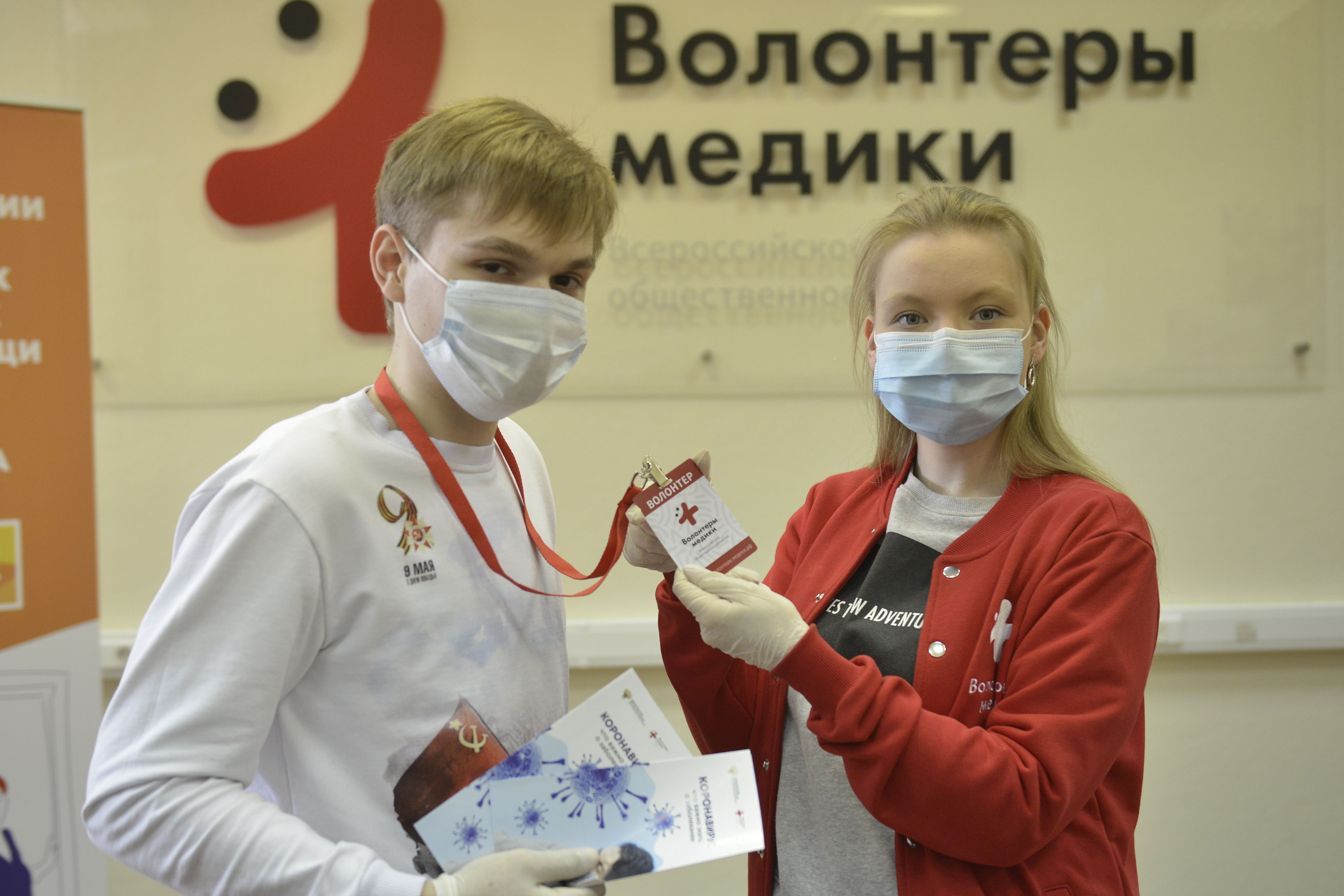 Руководитель столичного штаба организации «Волонтеры-медики» Дарья Белимова (справа) вручает бейдж добровольцу Владиславу Мунтяну, который прошел обучение и теперь готов помогать врачам и медсестрам в больницах и поликлиниках города