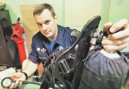 Руководитель смены поисково-спасательного отряда «СпасРезерв» Евгений Назаревский осматривает кислородный баллон перед заступлением на дежурство