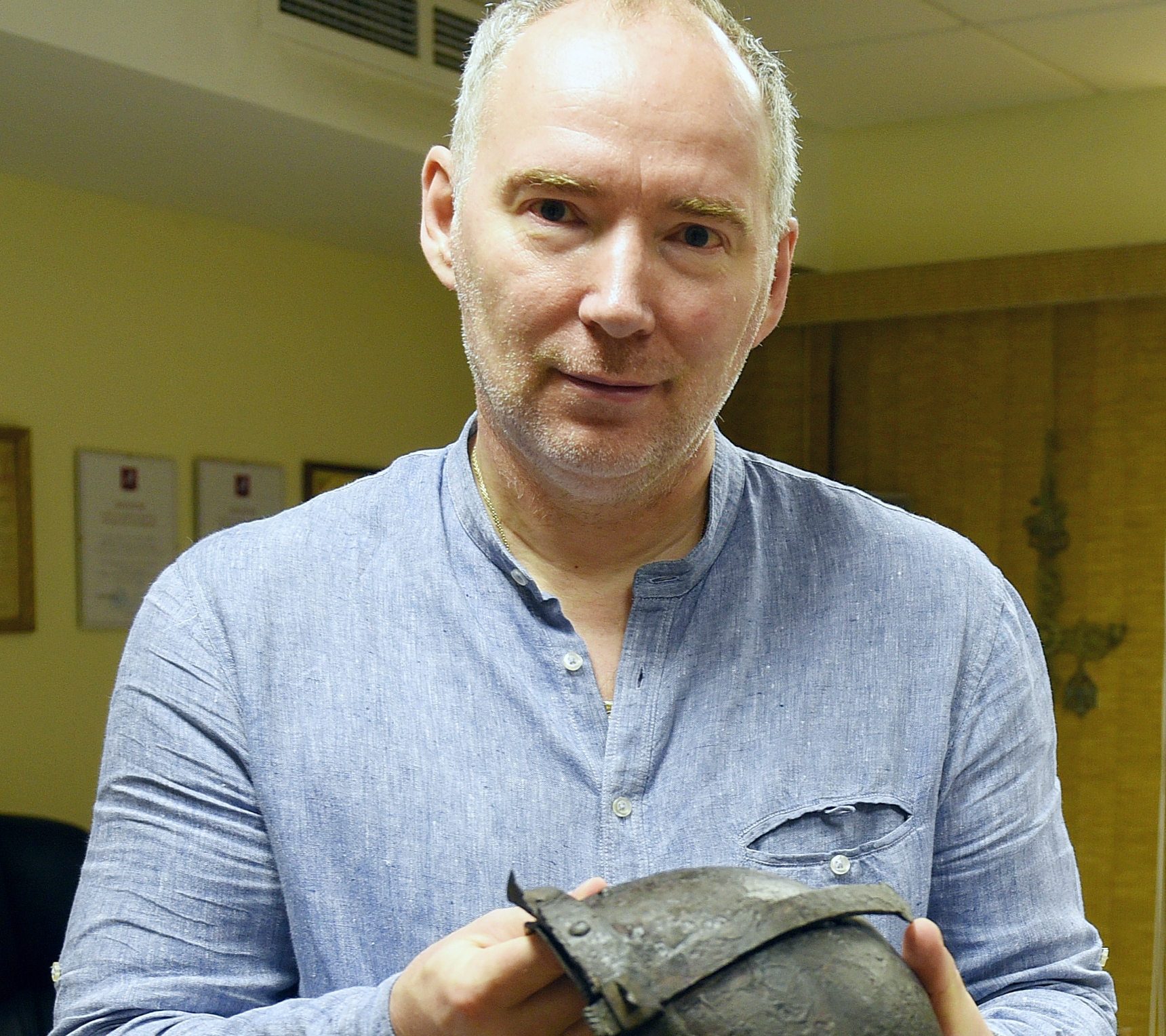 Генеральный директор «Столичного археологического бюро» Константин Воронин показывает шлем, найденный на Биржевой площади