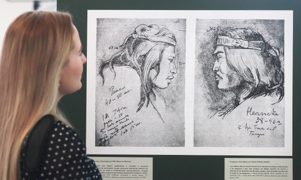 Посетительница рассматривает рисунки на открытии выставки редких книг и рукописей в Большом зале Дома Пашкова в Москве