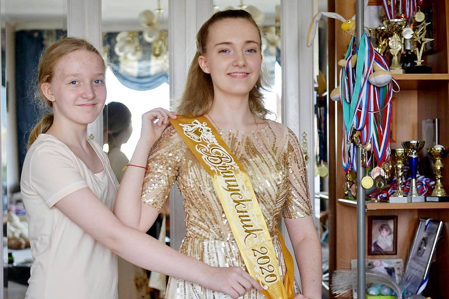 Анастасия Перегудова (слева) помогает старшей сестре Марии выбрать наряд на выпускной вечер. В легком золотистом платье можно пойти на торжественную часть, которая пройдет в школе. А вот в Парк Горького Мария думает надеть более практичный, но не менее праздничный наряд