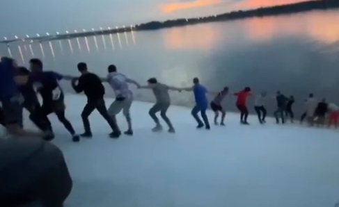 Около тридцати человек, проходивших мимо, выстроились в цепочку, взялись за руки и вытянули женщину