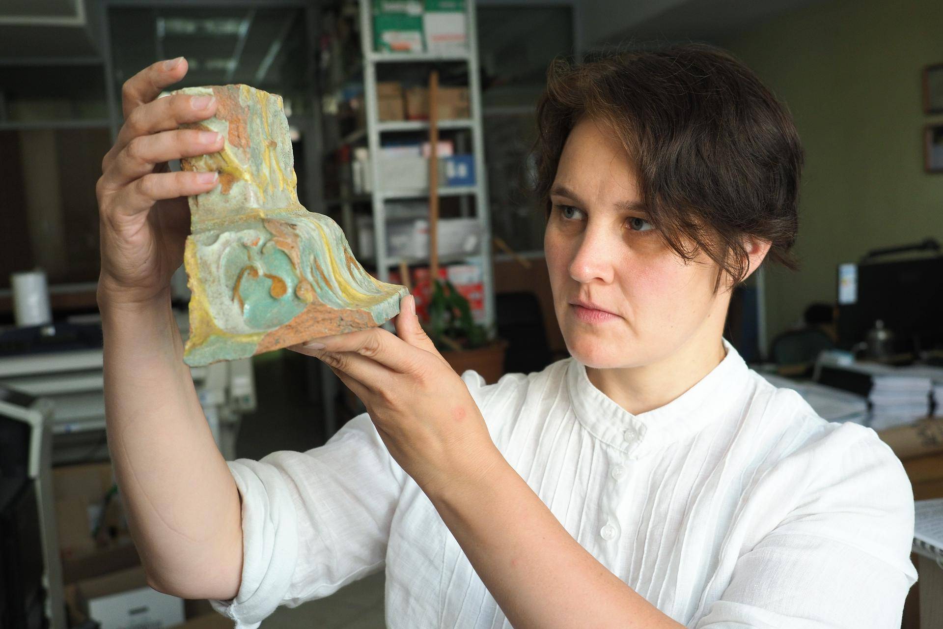 Начальник камерального отдела Столичного археологического бюро Людмила Рукавишникова демонстрирует изразец, который нашли на территории Пушкинского музея
