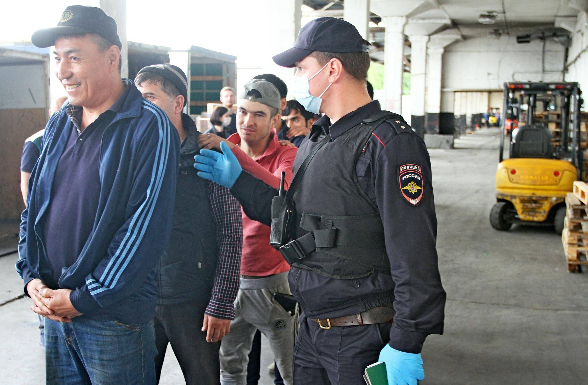 Сотрудник патрульно-постовой службы Управления внутренних дел Южного административного округа, прапорщик полиции Сергей Кузнецов препровождает задержанных иностранцев в автозак. Мигранты нарушили сроки пребывания в Российской Федерации