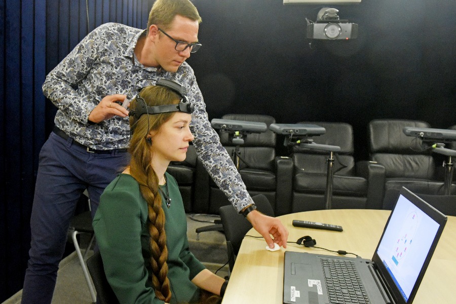 Директор по развитию столичной инновационной компании Илья Ильинцев и сотрудник патронажной службы Наталья Кучеева демонстрируют работу коммуникационной системы «НейроЧат», созданной для общения людей с ограничениями речи и движений