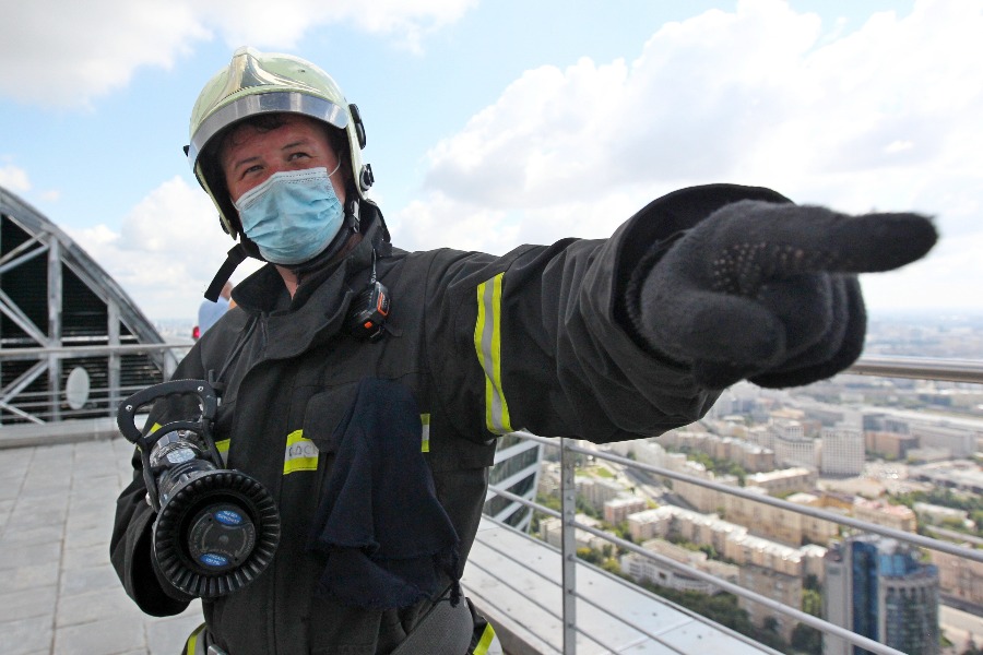 Пожарный 207-го спасательного отряда Дмитрий Соловьев на крыше высотного комплекса «Империя» руководит подачей огнетушащей смеси на 230-метровую высоту