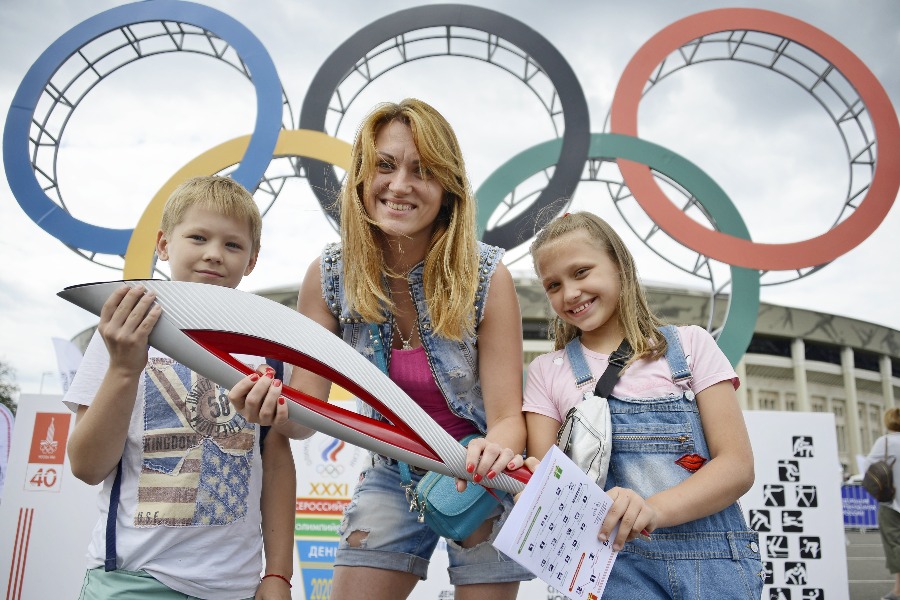 Наталья Сиделева (в центре) привела своих детей Даниила и Дарью на праздник, чтобы сфотографироваться с олимпийским факелом 2014 года и помочь им выбрать тот вид спорта, которым они хотели бы заниматься