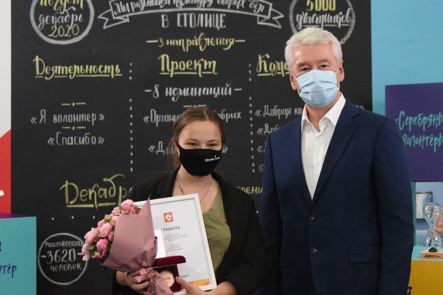 Мэр Москвы Сергей Собянин вручает добровольцу «Мосволонтера» Дарье Курбатовой диплом и памятную медаль за участие в общероссийской акции #МыВместе