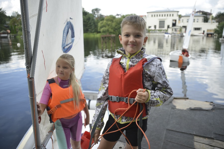 Юные участники соревнований Александра Харлашкина и Иван Морозов самостоятельно готовят яхту к водным гонкам. Как это правильно делать, их обучили в яхт-клубе