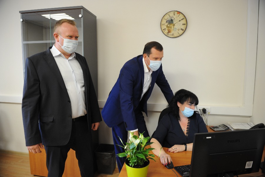 Заместитель главы Департамента финансов города Москвы Александр Беляков (слева) и префект ЦАО Владимир Говердовский наблюдают за работой ведущего специалиста спеццентра учета Анны Тарасовой