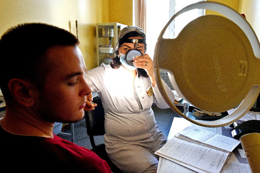 Врач-оториноларинголог Тамара Визавитина осматривает москвича Антона Самарина в ходе весенней призывной кампании. По ее итогам план был выполнен полностью. Около 79 процентов призывников стали военнослужащими, а остальные пополнили ряды войск МЧС и национальной гвардии