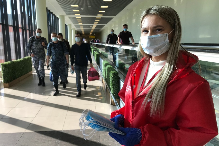 Волонтер Анастасия Батрутдинова раздает защитные маски пассажирам терминала Е аэропорта Шереметьево
