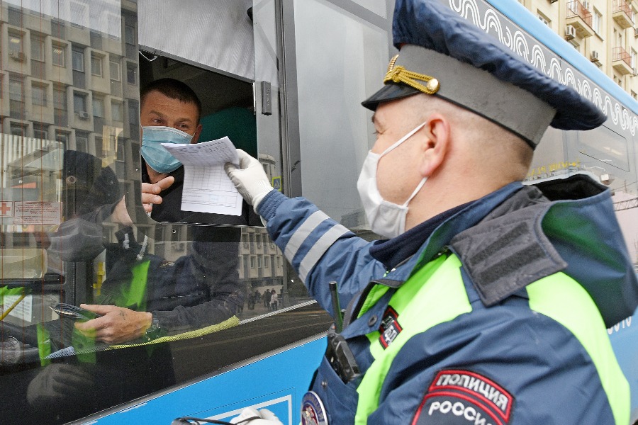 Инспектор дорожно-патрульной службы ГИБДД Управления внутренних дел Центрального административного округа Сергей Николаев во время рейда проверяет документы и наличие защитной маски у водителя автобуса Сергея Алексеева