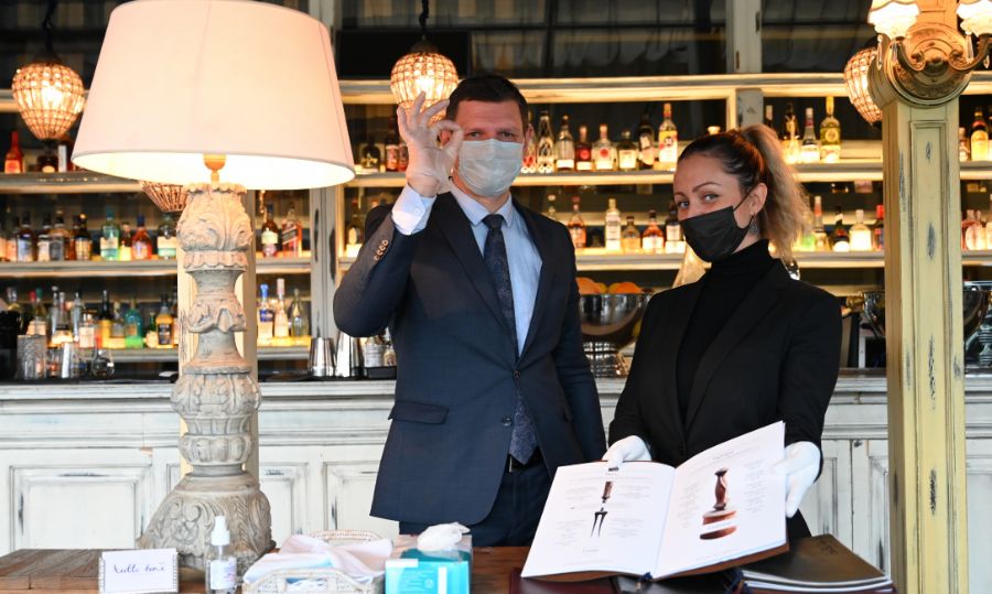 Метрдотель Алексей Букатин и менеджер Кристина Боросан встречают посетителей в ресторане одного из небоскребов «Москвы-Сити». Весь персонал заведения меняет маски и перчатки каждые два часа