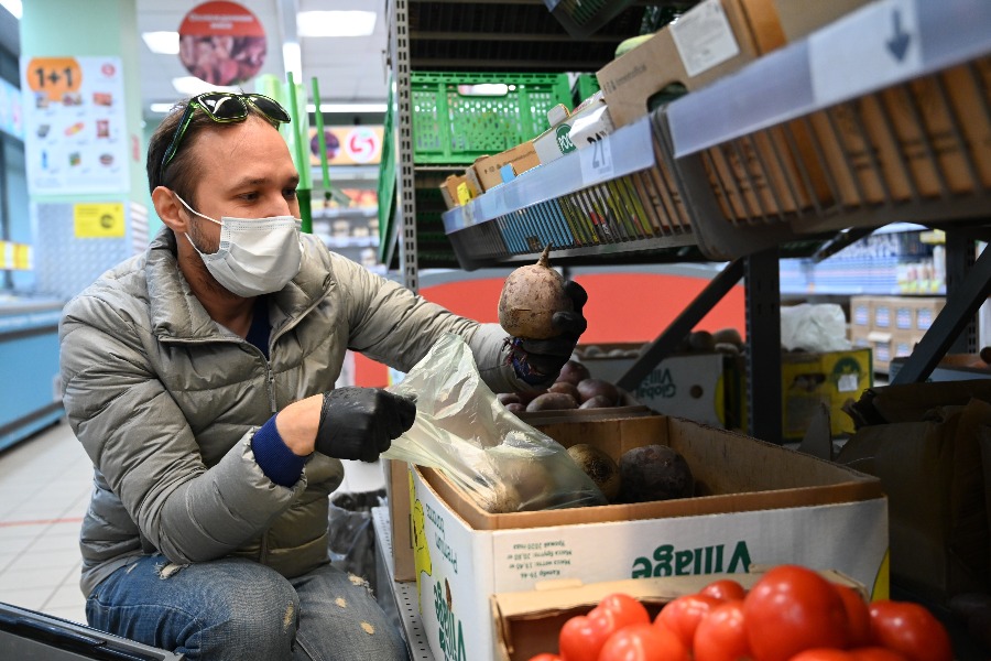 Участник конкурса «Доброволец Москвы — 2020» Антон Умников покупает в магазине овощи, крупы и другие необходимые товары. Волонтер отнесет продукты пожилым людям, которые остаются дома из-за пандемии 