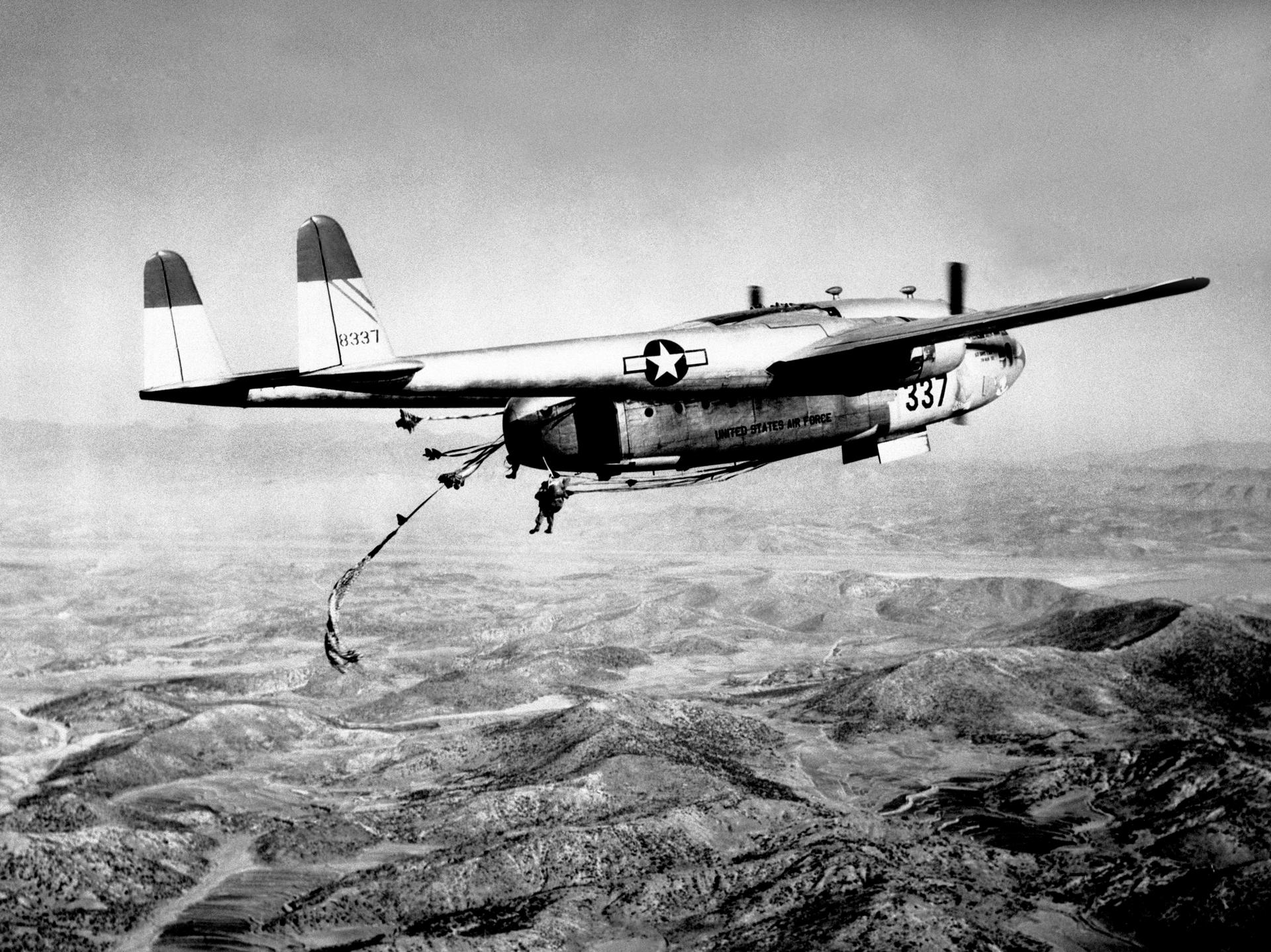Американский военно-транспортный самолет C-119 сбрасывает армейский десант и вооружение на территорию Кореи